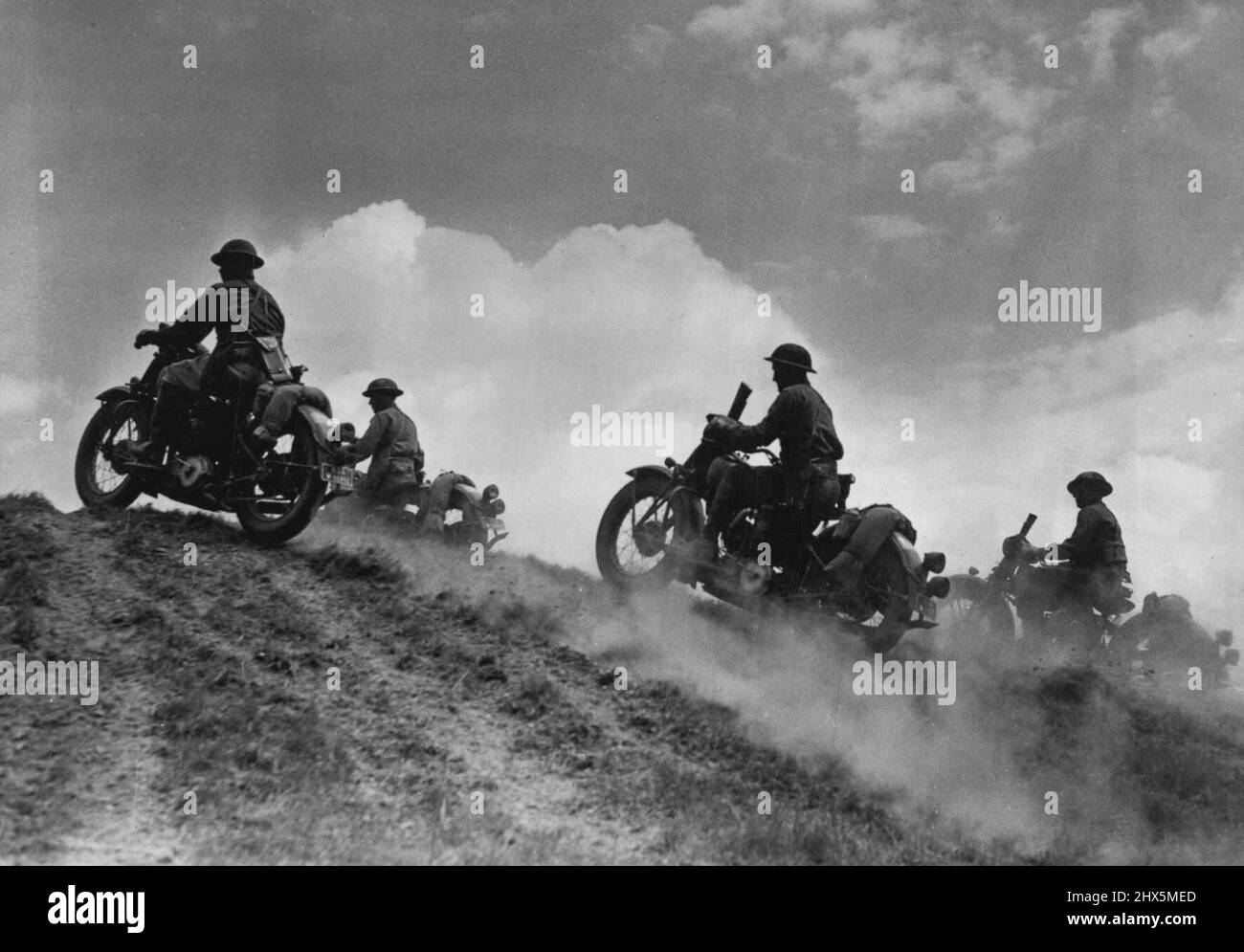 I ciclisti soldato degli Stati Uniti vanno 'oltre la cima' - le nuvole di Cumulus sopra, le nuvole di polvere sotto le truppe del motociclo degli Stati Uniti vanno 'sopra la gobba' nelle manovre da qualche parte negli Stati Uniti. Agosto 06, 1942. (Foto di Black Star). Foto Stock