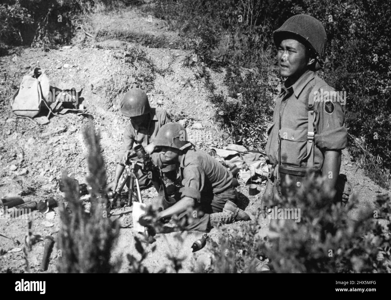 American of Japanese Ancestry Fire on German Snipers in Italy -- i soldati statunitensi di discesa giapponese sparano un mortaio sulle colline sul fronte italiano, dove i cecchini tedeschi sono attivi. I soldati appartengono al famoso Battaglione di fanteria del 100th della Quinta Armata alleata, composto quasi interamente da americani di ascendenza giapponese delle Hawaii. Già citato lontano gallantry come unità dal tenente statunitense Mark W. Clark, comandante della Quinta Armata alleata, i 100ths soldati hanno vinto nove distinte croci di servizio, 44 Silver Stars e tre Logion di Merit Medals. Mille uomini di battaglioni Foto Stock