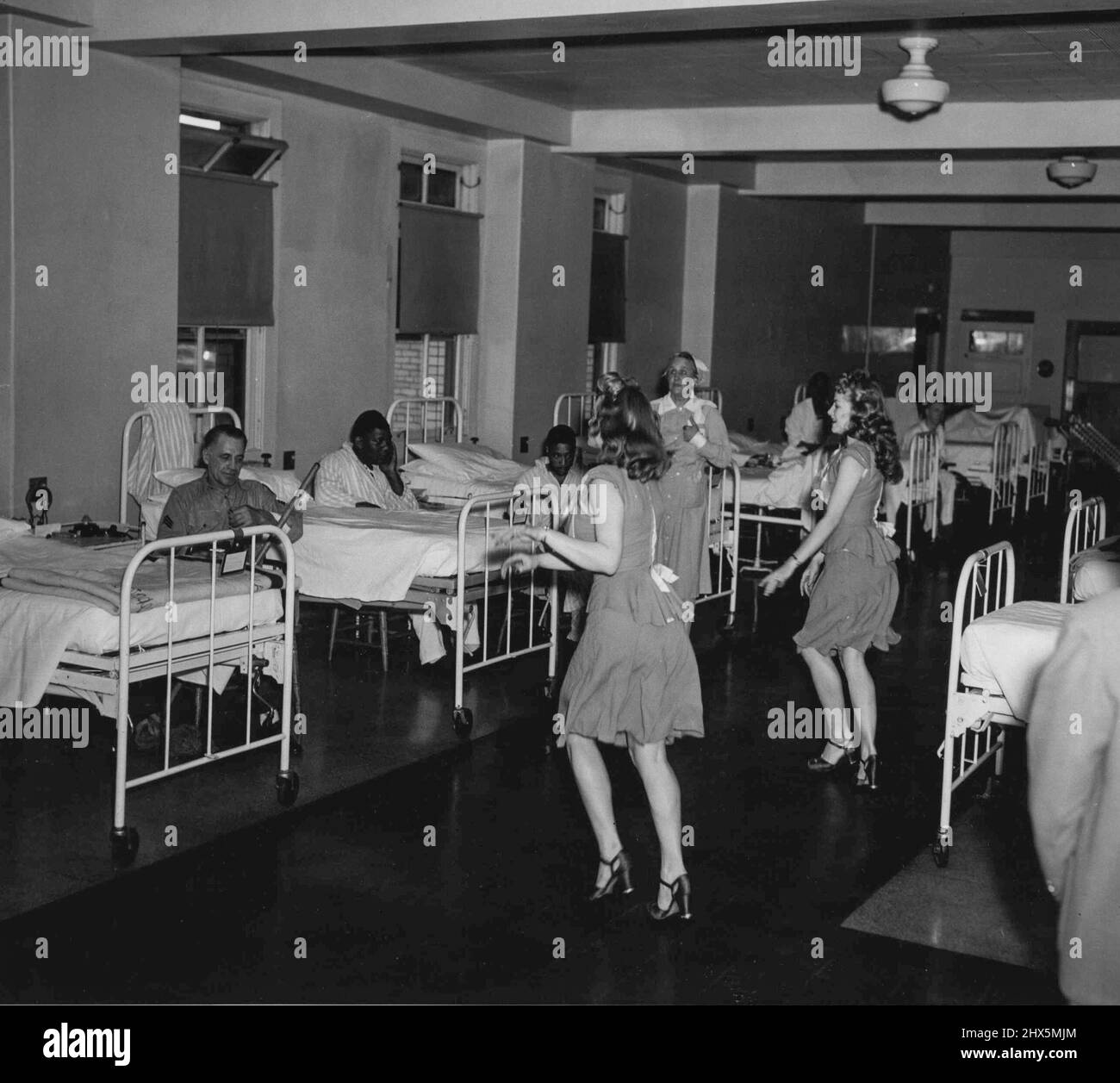 Il Ward's A Stage -- la troupe 'Girl Crazy' degli spettacoli USO-Camp, una delle 22 aziende che attualmente visitano 192 ospedali in questo paese, apre un'apparizione all'ospedale navale di Philadelphia, Pa., con uno spettacolo Vaudeville in un angolo del reparto dell'Amputee. Contemporaneamente un'altra unità si stava girando in altri reparti dell'ospedale. June Miller e Gypsy Ann Stell (a destra), compongono la squadra di ballo mostrata qui. Maggio 23, 1947. (Foto di ACME). Foto Stock