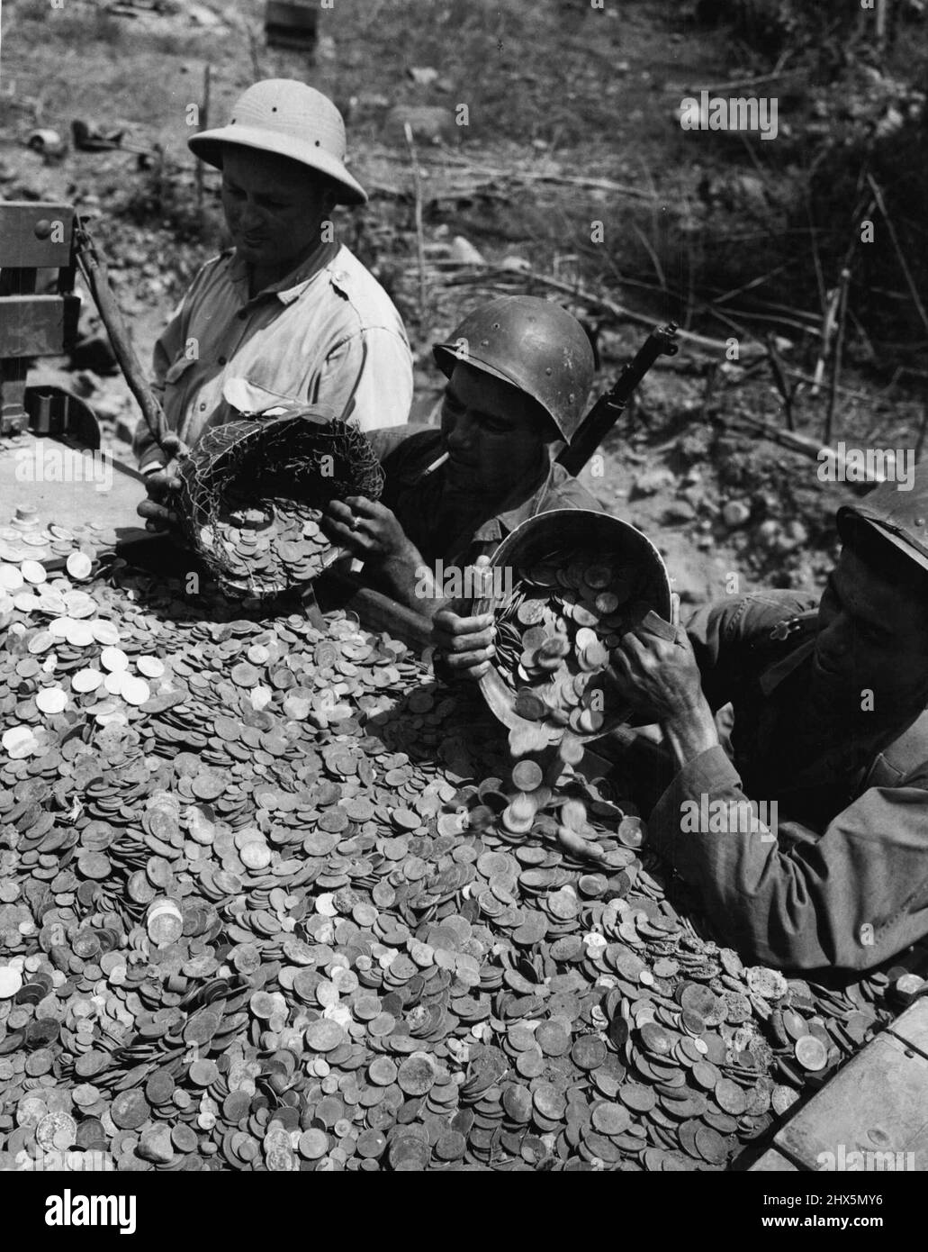 Grande caduta di denaro: Contanti crashed! I soldati americani ricaricavano un camion con mezzo milione di dollari di filippino e monete americane che erano state soffiate da esso da fuoco diretto di artiglieria su Luzon. Marzo 31, 1945. (Foto di USA Signal Corps Photo ). Foto Stock