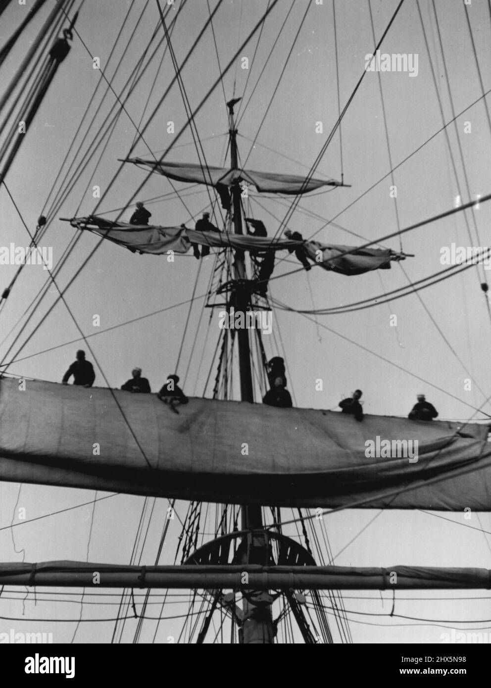 I cadetti a bordo del Sorbandet ricevono un'accurata formazione di marinai durante i viaggi. Ecco alcuni di loro che prendono la tela sulle braccia del cortile mentre la nave si avvicinava all'estuario del Tamigi. Giugno 17, 1952. (Foto di Daily Mirror). Foto Stock