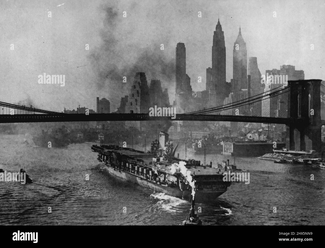Vettore Roosevelt Gail's Down East River -- con lo skyline di New York come ritorno, il vettore aeroporto Franklin D. Roosevelt, Che è stato commissionato il giorno della Marina dal presidente Harry S. Truman, naviga lungo il fiume Est, N.Y., Novembre 16, sotto il ponte di Brooklyn il vettore sta lasciando il New York Navy Yard, Brooklyn, N.Y., per ulteriore condizionamento presso il Navy Yard Annex, Bayonne, N.J. In base ai piani attuali la nave continuerà la sua crociera shakedown in circa due mesi. Novembre 16, 1945. (Foto di stampa associata). Foto Stock