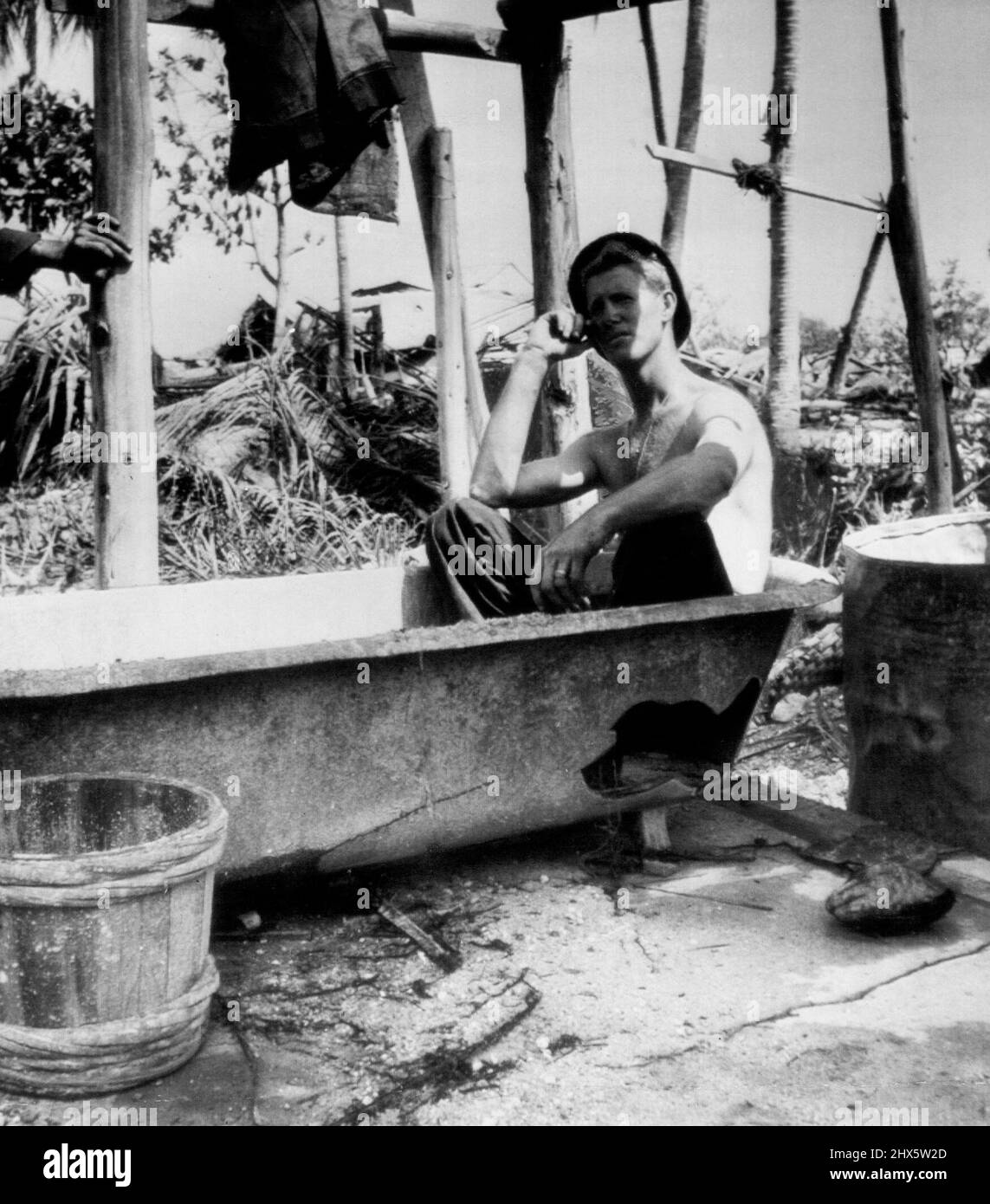 Una vasca da bagno! John C. Smith, Gadsden, Ala., siede nell'unica vasca dell'isola di Makin nel gruppo di Gilbert dopo che è stato catturato dalle forze americane e desidera che potesse fare il bagno. Ma un frammento di shell è arrivato per primo. Dicembre 18, 1943. (Foto Wirephoto AP). Foto Stock