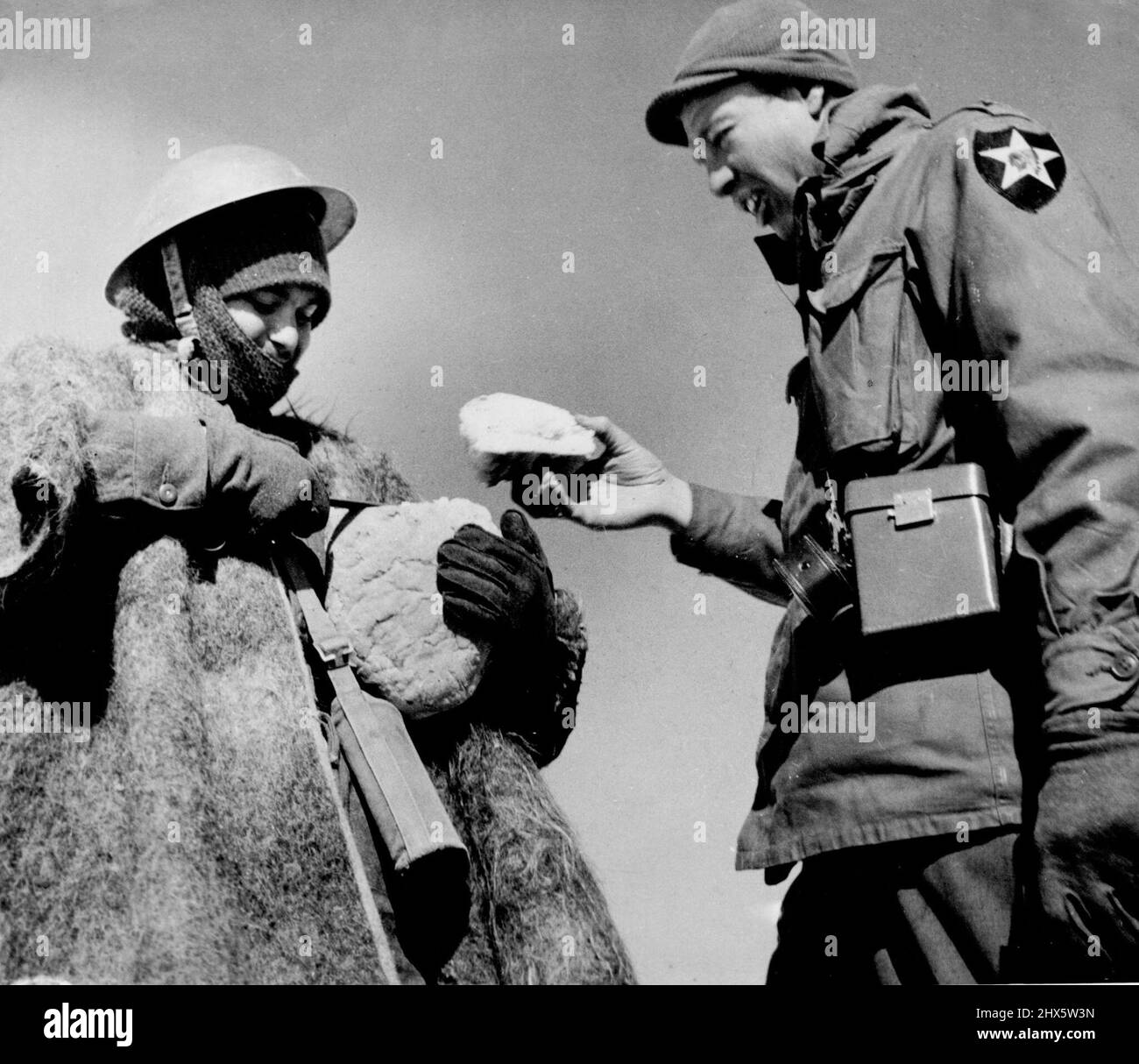L'osservatore degli Stati Uniti ottiene il bread RationCapt. Leroy Welch (a destra), di Denver, Colom., riceve il suo ration di campo del pane da un pagnotissimo da un soldato greco. Welch è sul campo con la divisione greca di montagna del 15th concentrata contro i guerriglieri a un miglio dal confine albanese a nord-ovest di Kastoria. Veterano dei combattimenti di montagna in Italia, Welch è sulla sua prima missione di combattimento con i greci. Per osservare le loro operazioni e suggerire miglioramenti. Febbraio 22, 1948. (Foto di stampa associata). Foto Stock
