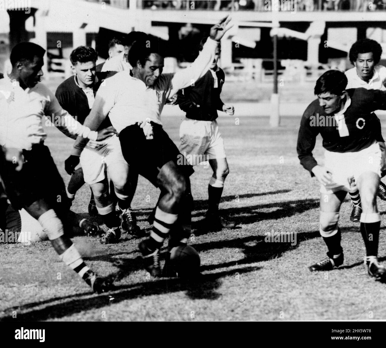 Fiji V Qld. Un Fijiian in avanti con la palla al piede porta il campo di gioco in territorio Queensland. Luglio 23, 1952. (Foto del giornale Telegraph Co.Ltd.) Foto Stock