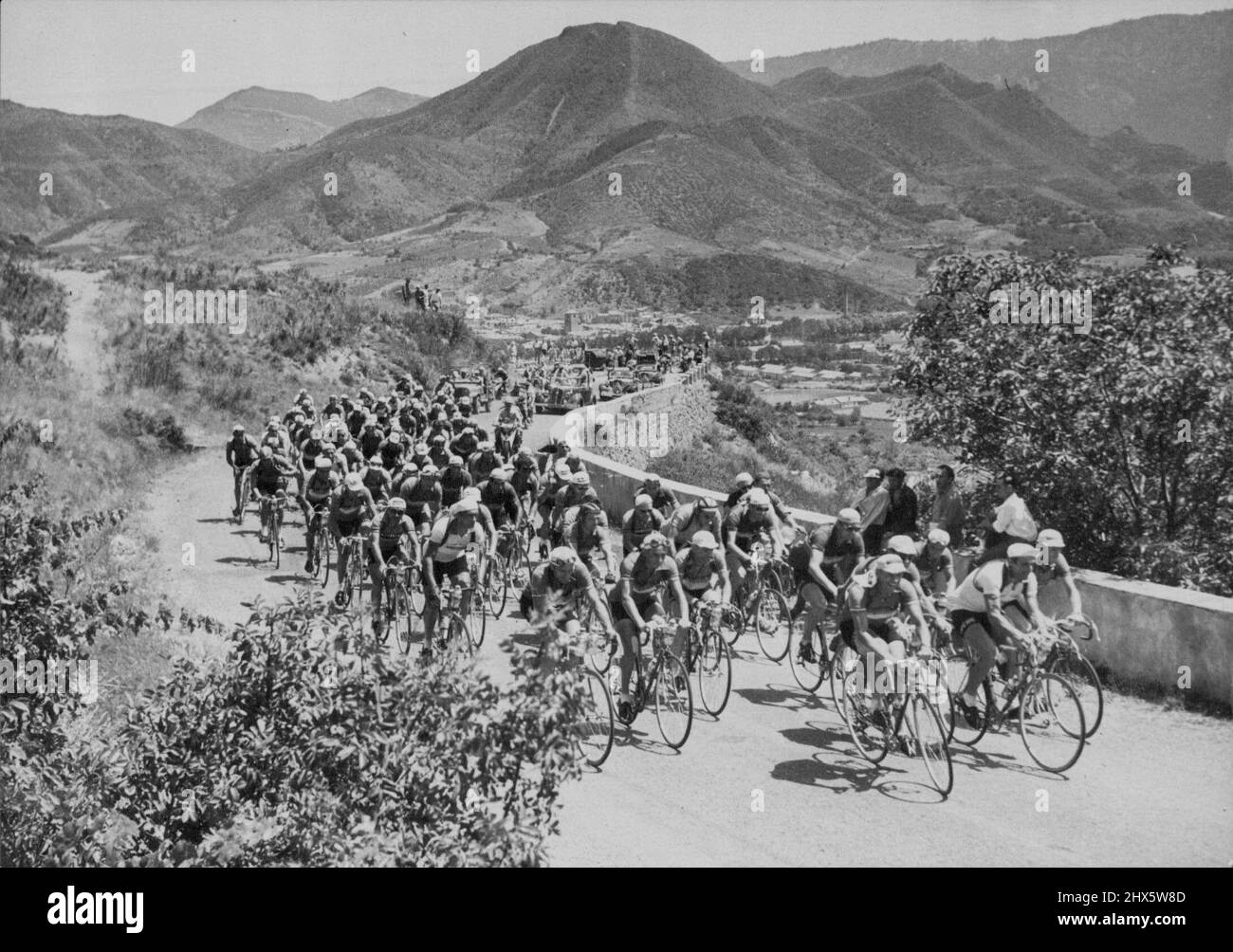 Una scena tipica del Tour de France in uno dei periodi più riposanti con il campo che fa la sua strada lentamente in un paese aspro. Il Tour De France Cycling - il pacchetto nelle prime piste dei Pirenei. 24 agosto 1953. Sport, sport, atleta, atletica, Foto Stock