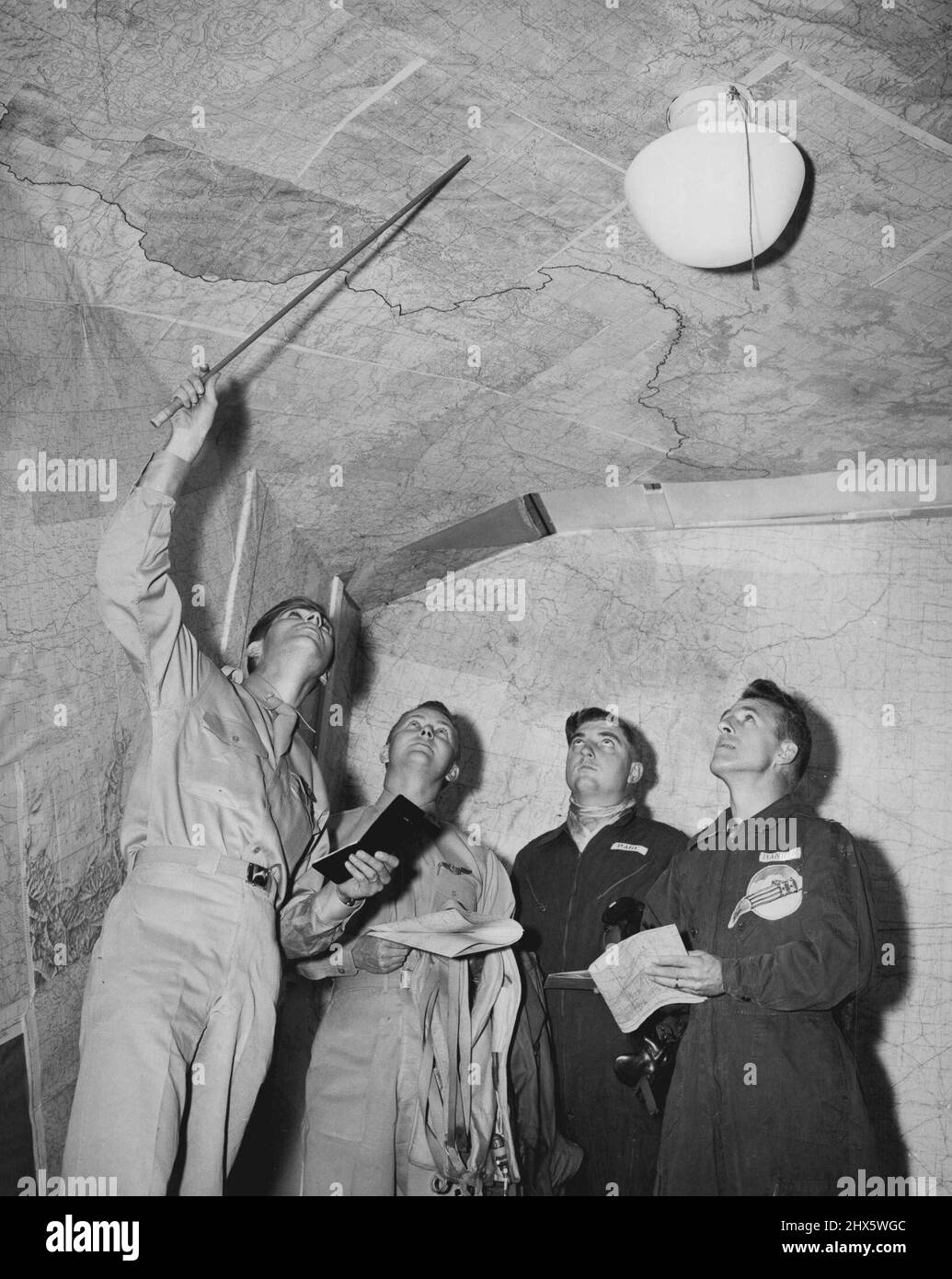 Il pilota diventa un Jockey Fireman (quarto di otto) -- volando intorno a 500 o più miglia all'ora, un pilota del jet copre un sacco di territorio in un breve tempo. Pertanto, i piloti devono avere familiarità con una grande area prima di poter prendere in aria. Qui. Il Lt. Hugh Turner, di Taylors, S.C., presenta il futuro 'fantini' con l'aiuto di mappe che coprono il soffitto e le pareti. Con i turner sono (da sinistra a destra): Lt. Prezzo Foto Stock