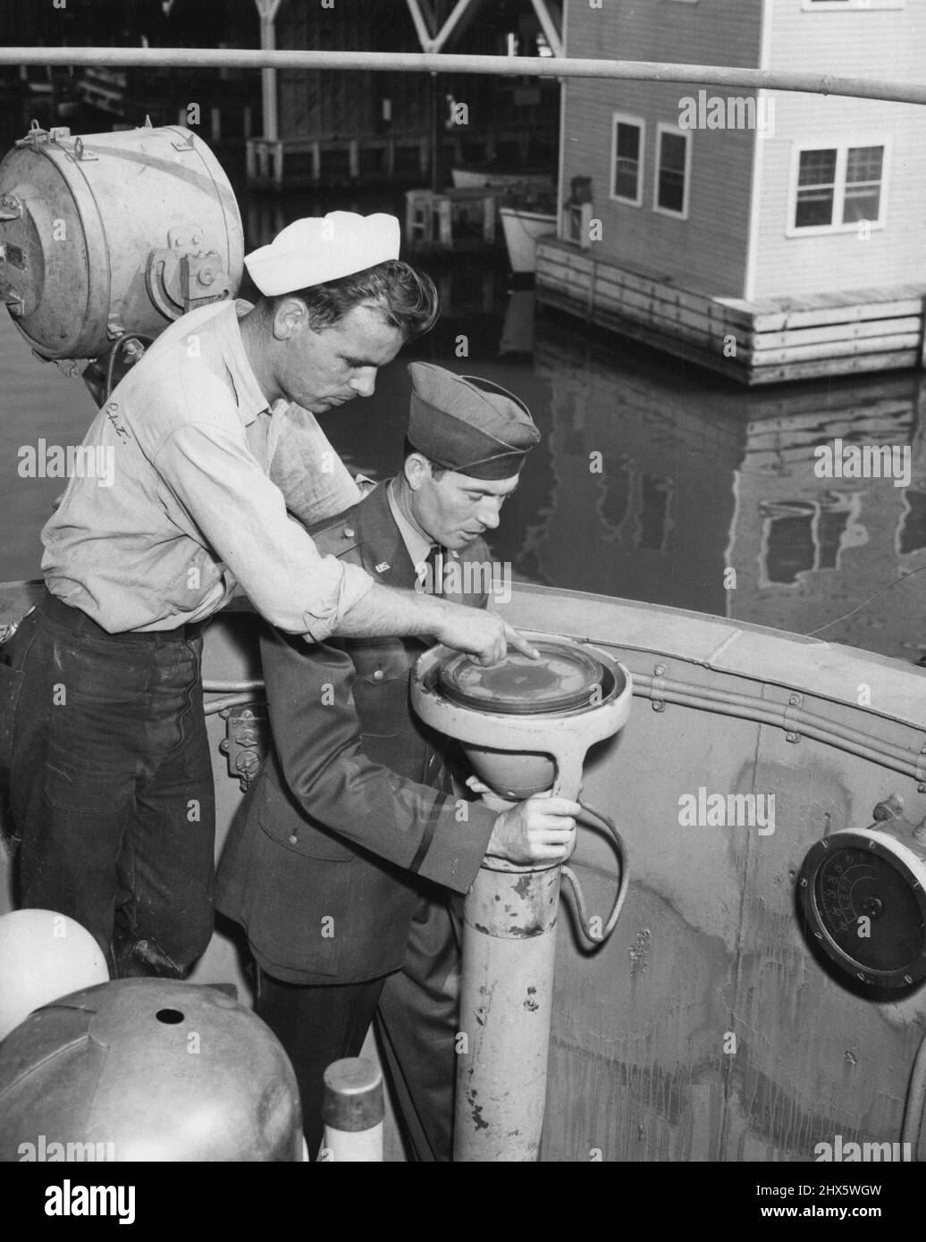 Uno di Un genere (terzo di dieci) -- ottenere il appeso della bussola della nave che differisce da quelli sugli aerei sono lo skipper, 1st Lt. Alvin Garner (a destra) e il Bosun, S/Sgt. Robert E. Sjosten, che indossa un cappello Navy. Settembre 3, 1951. (Foto di ACME). Foto Stock