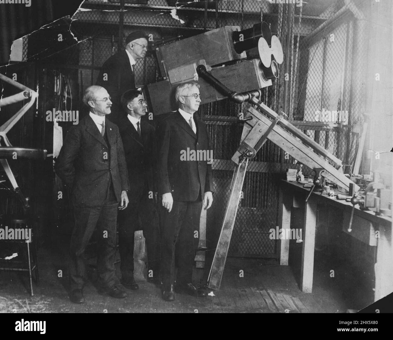 Scienziati della Marina per fotografare Sun's Eclipse -- Sopra è mostrata la macchina fotografica gigante per mezzo della quale gli scienziati della marina sperano di fotografare l'eclisse del sole, che si prevede si svolgerà gennaio 24th. La macchina fotografica enorme è stata costruita appositamente per questo test, per essere fatta dal nave dirigibile shenandoah. In primo piano è il capitano E.T. Pollock, sovrintendente dell'osservatorio Navale degli Stati Uniti, che sarà responsabile delle prove. Alla fotocamera viene mostrato il fotografo della marina. George H. Peters Foto Stock