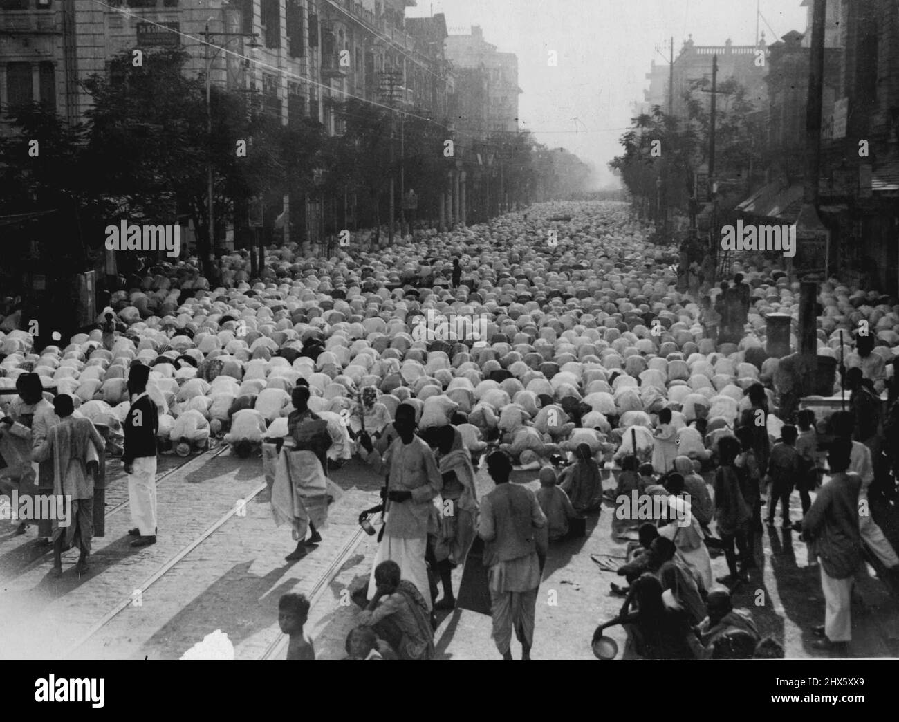 Moslem a Calcutta ***** Il compleanno del Profeta: Celebrazioni in molti presti diversi quest'anno da parte di truppe indiane di stranieri ***** il compleanno del profeta è stato celebrato con lo stesso fervore a Calcutta. Questa foto, presa in una strada principale dalla Città, mostra come la strada è stata completamente bloccata da masse di oranti moschem. Nota i molti mendicanti in primo piano, in attesa con le loro elemosine - bocce per quando il servizio termina e la folla di musulmani streaming mostrerà generosità Foto Stock