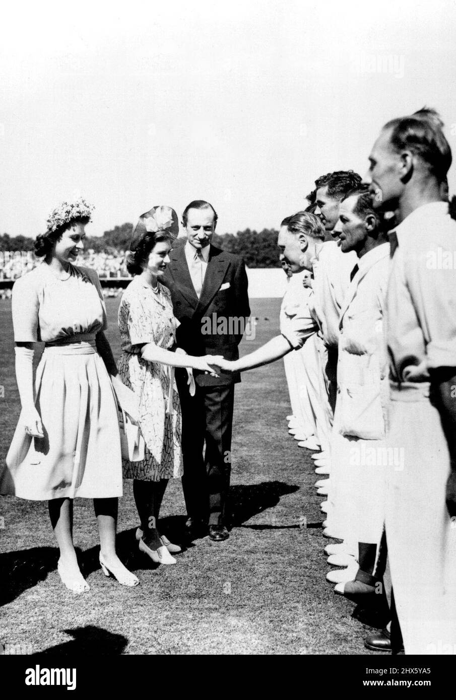 La famiglia reale incontra gli Eleparen di prova -- il re e la regina con le due principesse visitano i Lords durante il secondo incontro di prova fra l'Inghilterra ed il Sudafrica. Era la prima volta che le Principesse guardavano un incontro di prova. La principessa Elizabeth e la principessa Margaret hanno visto con la squadra inglese. Ad accompagnarli è il sig. Ronald Aird, segretario aggiunto del C.C., e la principessa Margaret sta scuotendo le mani con Hollies, il bowler del Warwickshire. Accanto a lui c'è Bedser, e più vicina Camera H. Haldwin (umpire Foto Stock