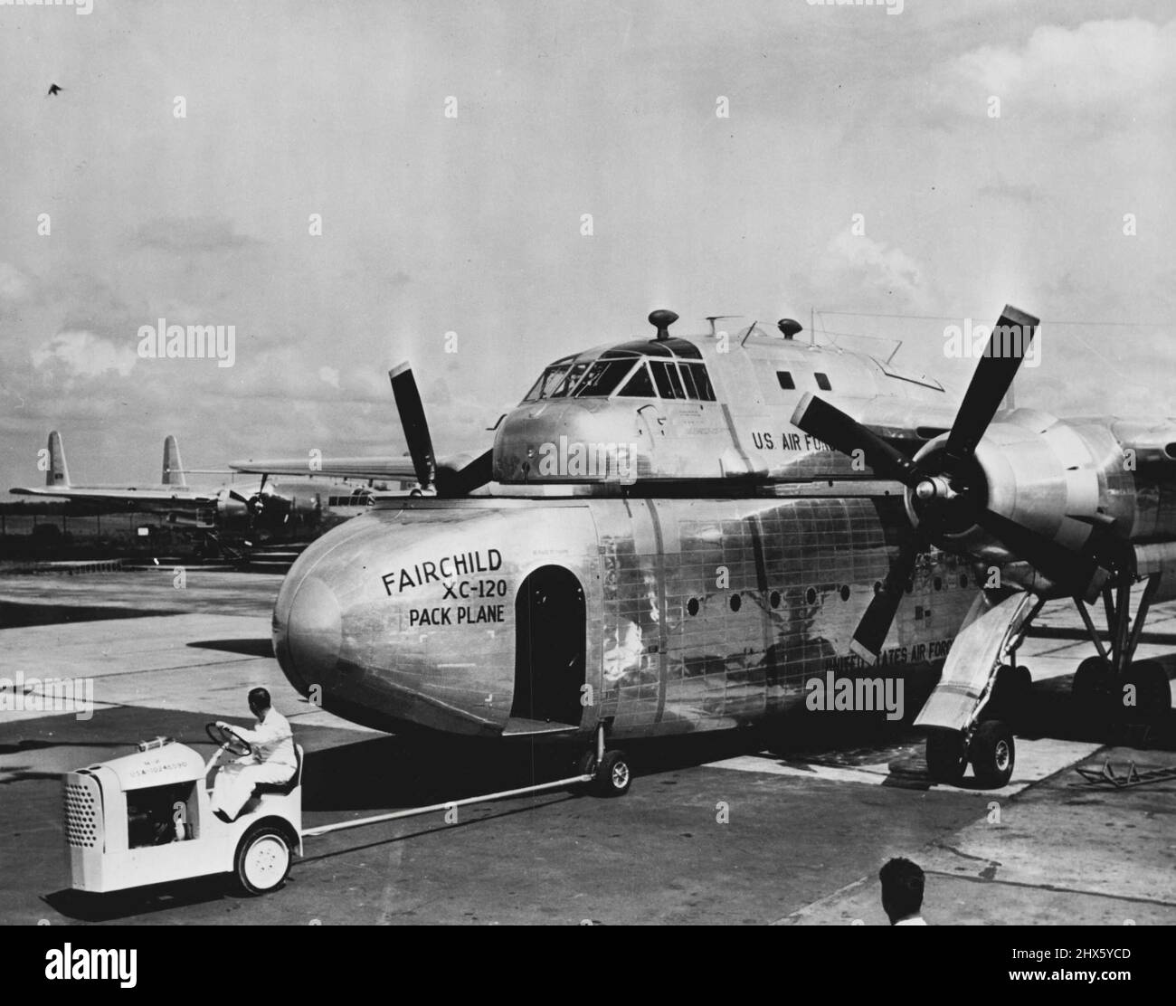 Un trattore che traina il vano di carico rimovibile dal piano di imballaggio XC-120. Un velivolo di trasporto staccabile-fusoliera è stato dimostrato recentemente dall'aeronautica degli Stati Uniti a Hagerstown, Maryland. Noto come Fairchild XC-120 Packplane, il monoplano ad ala alta, a doppia inginatura, trasporta un 'pod' rimovibile che può trasportare 36 pazienti di figliata, 64 truppe completamente equipaggiate, o 20.000 libbre di carico. Durante il funzionamento, gli aeroplani sono progettati per volare in un'area in avanti, con la fusoliera o la pod staccata Foto Stock