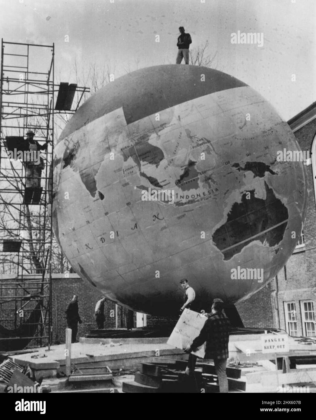 Questo mondo è facilmente patched Up -- Un uomo di lavoro si alza in cima a un globo di acciaio $200.000 del mondo che sta per completarsi al Babson Institute of Business Administration. Per essere utilizzata dagli studenti di geografia, la sfera ha un diametro di 30 piedi, pesa 40 tonnellate e può essere ruotata ad angolo. Anche se Formosa e le isole controverse lungo la costa cinese sono state aggiunte ancora, i funzionari Babson dicono che il globo è progettato in modo da ciascuno di circa 500 piatti può essere rimosso per i cambiamenti per tenere il passo con gli eventi del mondo. AP Foto Stock