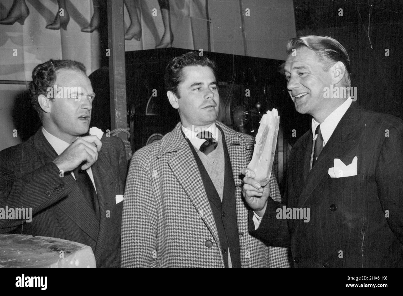 Tre uomini e un certo formaggio -- tre Eroi di Bobbie-Sox si incontrano ad un bazar di carità di Hollywood. Van Heflin, (a sinistra) e Sonny Tufts, (a destra) hanno appena assaggiato un po' di formaggio del Wisconsin e con reazioni ovviamente divergenti. Glen Ford, (centro) ha appena giocato al sicuro e guardato. Febbraio 23, 1947. (Foto di ACME Newspictures, Inc.).;tre uomini e un certo formaggio -- tre Eroi di Bobbie-Sox si incontrano ad un bazar di carità di Hollywood. Van Heflin, (a sinistra) e Sonny Tufts, (a destra) hanno appena assaggiato un po' di formaggio del Wisconsin Foto Stock