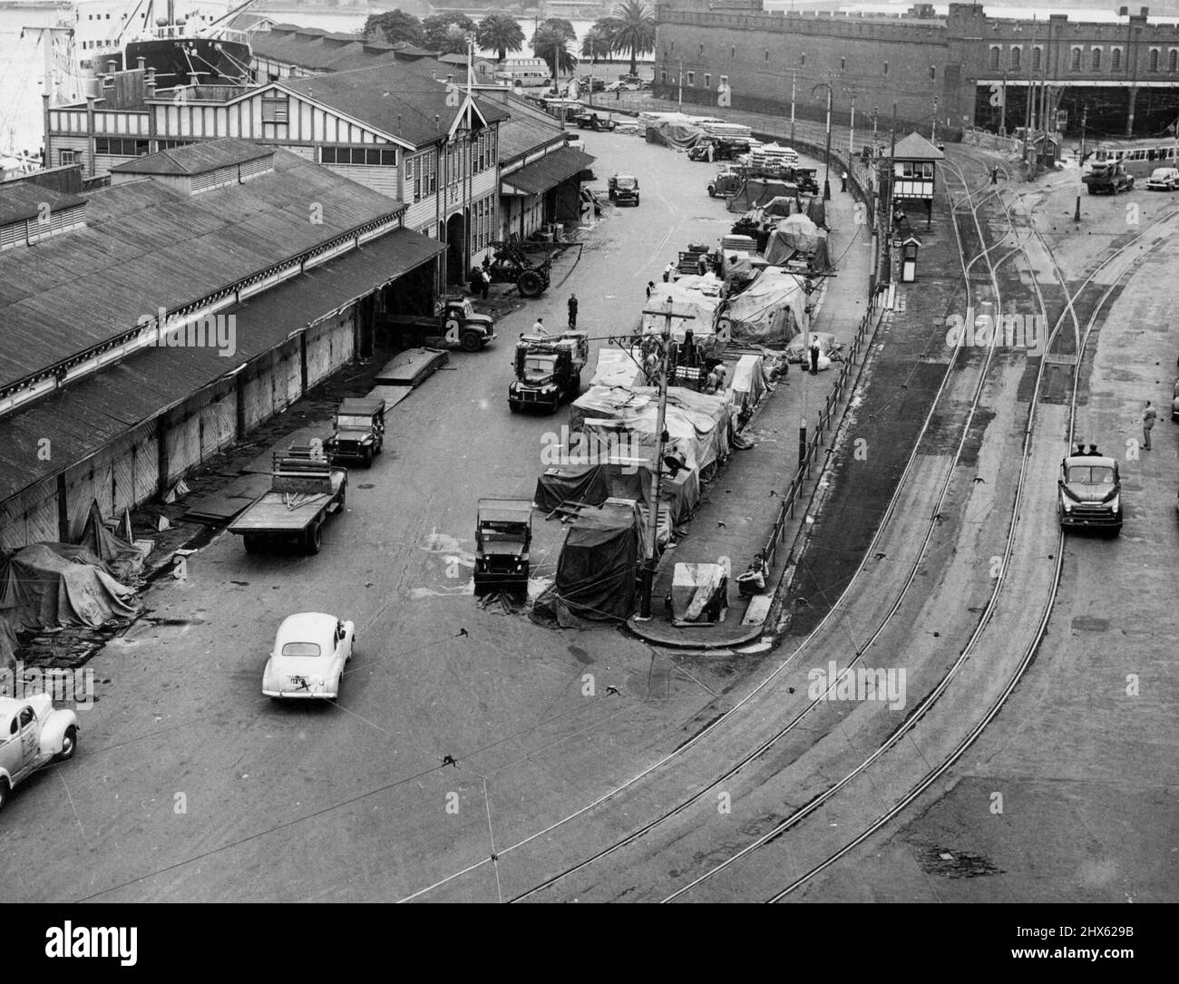 Carghi in strada -- scena a East Circular Quay oggi dove carghi hanno superato-fluito da capannoni di banchina per la strada. Intorno al porto di Sydney Waterfront 60.000 tonnellate di cibi attendono di essere rimossi. Aprile 10, 1952.;carghi in strada -- scena a East Circular Quay oggi dove carghi hanno superato-fluito da capannoni di banchina per la strada. Intorno al porto di Sydney Waterfront 60.000 tonnellate di cibi attendono di essere rimossi. Foto Stock