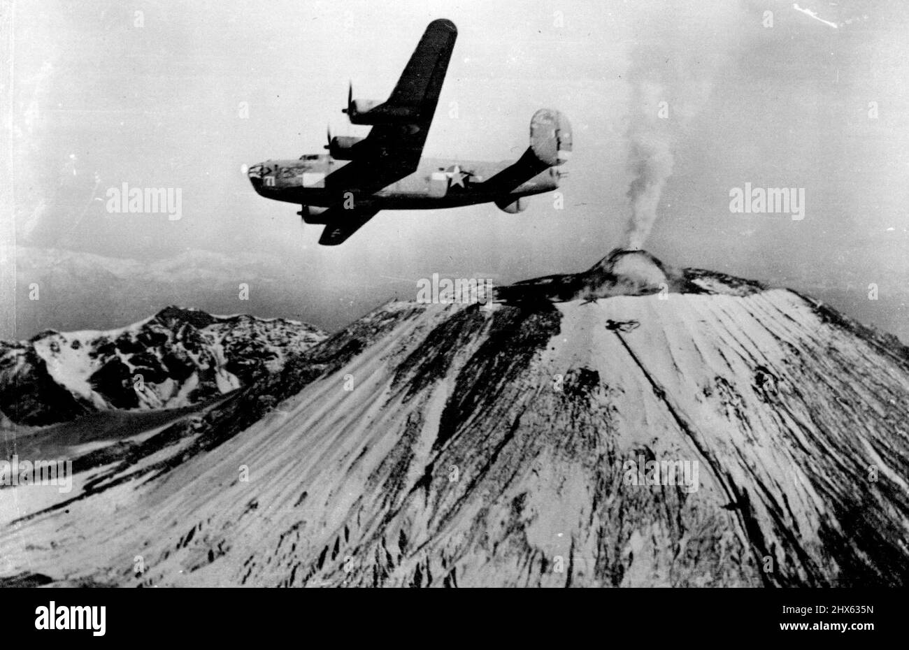 U.S. Liberator Over Vesuvio A B-24 Liberator bomber of the U.S. Army Air Forces circoli sopra le pendici innevate del Vesuvio. Il Liberator è il famoso "Blue Streak" in una missione in Italia dopo aver completato 1.058 ore di volo di combattimento durante le quali i suoi cannoni hanno portato giù 23 combattenti nemici senza perdere alcun membro dell'equipaggio, anche se la sua cornice è stata dotata di buchi di fiocco. Il "Blue Streak" è ora tornato negli Stati Uniti per una visita agli impianti di guerra industriale. Marzo 1, 1944. Foto Stock