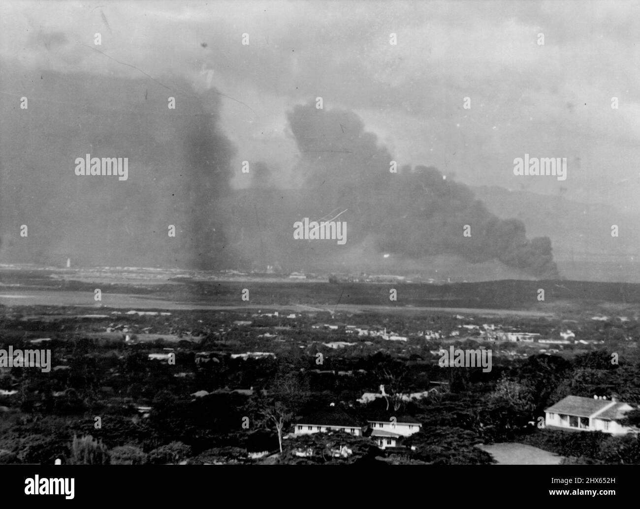 Pearl Harbor Burns dopo un attacco a sorpresa - Pearl Harbor, fortezza militare e navale degli Stati Uniti nel Pacifico, Si trova sotto un'inquietante pinacchiata di fumo nero dicembre 7 poco dopo che gli aerei giapponesi hanno bombardato il Porto e gli obiettivi militari circostanti, mentre i 'negoziatori di pace del Giappone' hanno ancora parlato di pace al Segretario Hull a Washington e l'ambasciatore degli Stati Uniti in Giappone è stato detto a Tokyo che Nipon desiderava la pace. La foto è stata fatta da Mt. Tantalo, dietro Honolulu. Dicembre 16, 1941. Foto Stock