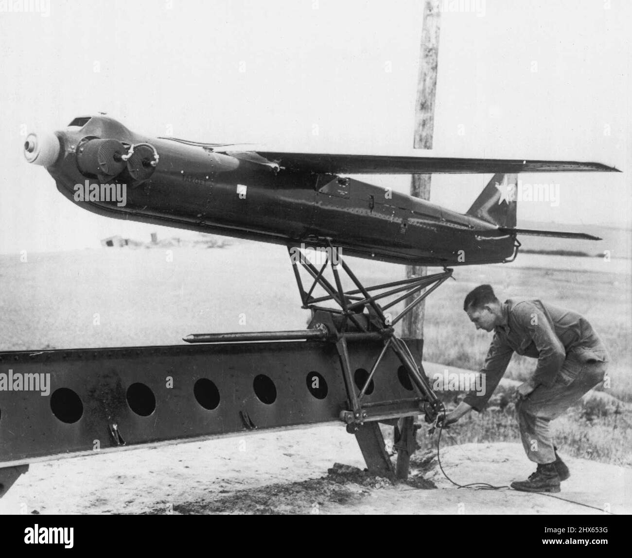 Target for Track-and-Destroy Anti-Aircraft Gun -- un 'R-Cat' 300 miglia all'ora, radiocontrollato aereo bersaglio è preparato per decollo alla dimostrazione a Weybourne, Inghilterra, durante la prova della nuova US 75mm Skysweeper Anti-Aircraft pistola. La nuova pistola, dimostrata per alti ufficiali e giornalisti britannici dal ponte di artiglieria antiaerea 32nd, ha un radar integrato e un cervello elettronico che funziona velocità di taglio, altezze e angoli. Può sparare 22 12-poounder conchiglie in 30 secondi al volo dell'aereo Foto Stock