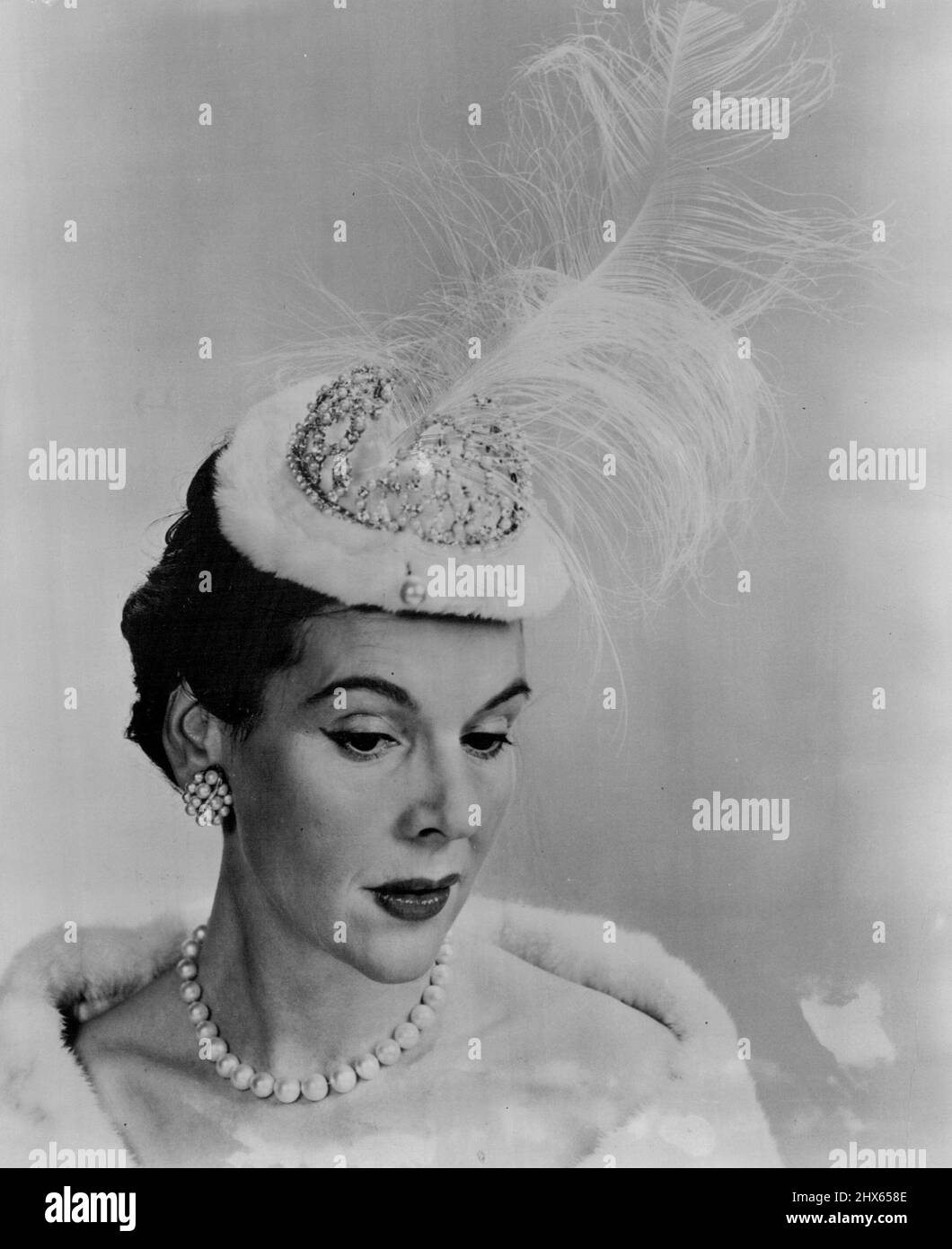 'rs Cornelius Vanderbilt Whitney indossa John's Coronation Chapeau' - 'mrs Cornelius Vanderbilt Whitney famosa bellezza della società americana è mostrato indossando MR. John's emozionante tesoro Tove tiara dalla sua 'incoronazione della Primavera 1953 e Estate Collection. Questo 'gioiello della Corona' è opportunamente chiamato, 'tesoro reale' e presenta una squisita coronetta di diamante con una deriva comandante di Aigrette reale su un cappuccio interno di ermine regale. Il signor John ha riconosciuto a lungo come re del mondo del cappello, predic Foto Stock