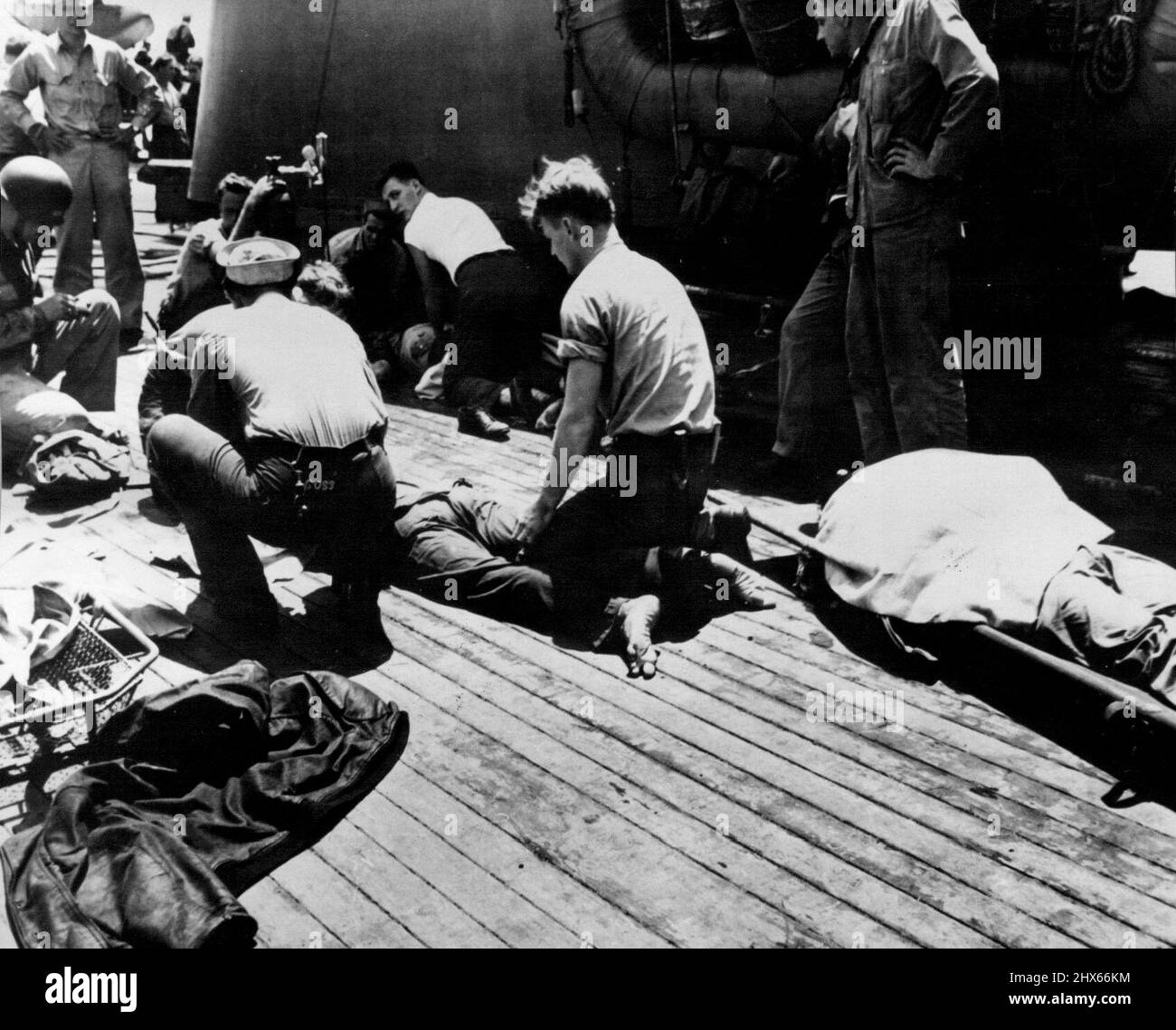 Uomini feriti dal portatore colpito U.S.S. Bunker Hill riceve un trattamento di primo soccorso a bordo dell'incrociatore leggero U.S.S. Wilkes barre, che ha giocato un ruolo importante nell'aiutare il vettore. Giugno 21, 1945. (Foto di ACME). Foto Stock