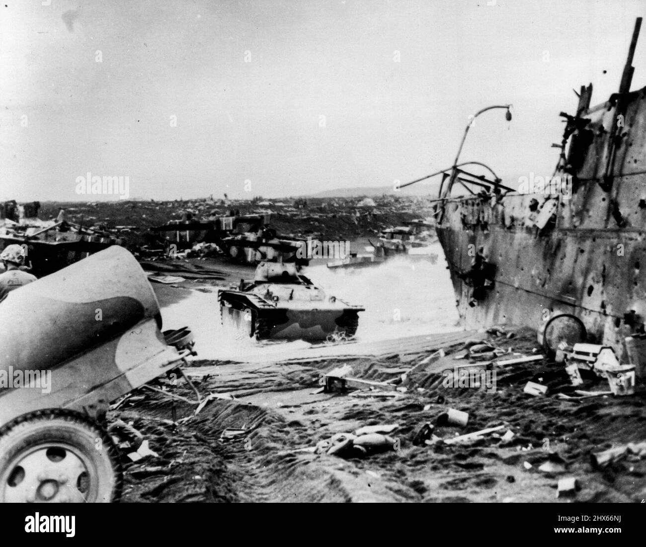 Tough Going -- scene come questa erano comuni sulla spiaggia a Iwo Jima il D-Day. Questa fotografia è stata fatta 'da un fotografo di combattimento della Guardia Costiera che è venuto a terra dalla sua LST con la Quarta Divisione Marina per registrare il loro atterraggio. Il suo Remark, inviato con le sue immagini, 'la guerra è l'inferno'. Un trasporto Jap, guidato da un incendio di conchiglie navali, è sulla destra. Marzo 6, 1945. (Foto della Guardia Costiera ufficiale). Foto Stock