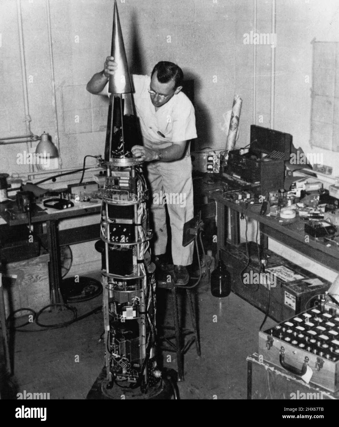 What Goes Up 90 Miles -- Ecco un'occhiata ai complessi strumenti elettronici compatti portati a 90 miglia in razzo sparatutto presso l'Holloman Air Development Center alla ricerca di informazioni scientifiche sull'atmosfera superiore. H.F. Scholte, ingegnere di progetto dell'Università del Michigan, qui lavora su una testa di strumento. Giugno 21, 1954. (Foto di AP Wirephoto). Foto Stock