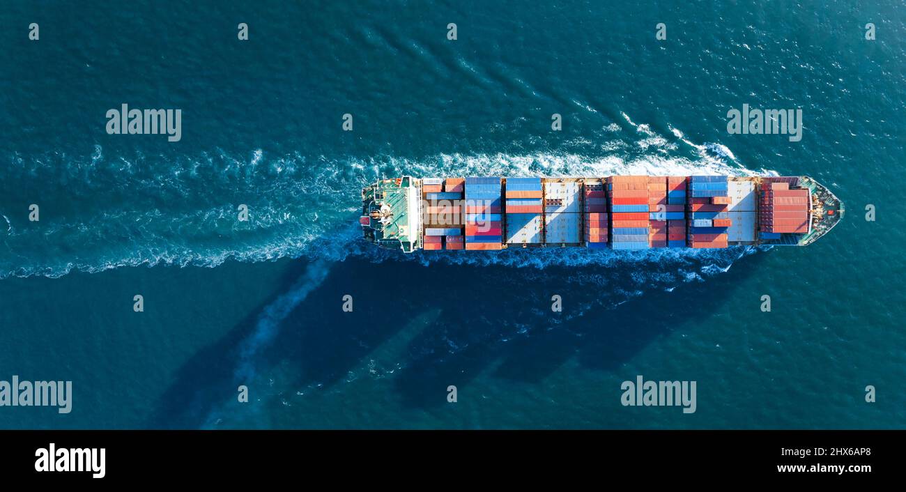Vista aerea dall'alto della nave da carico che trasporta container e che corre per esportare merci dal porto del cantiere di carico alla tecnica di trasporto oceanico su misura Foto Stock