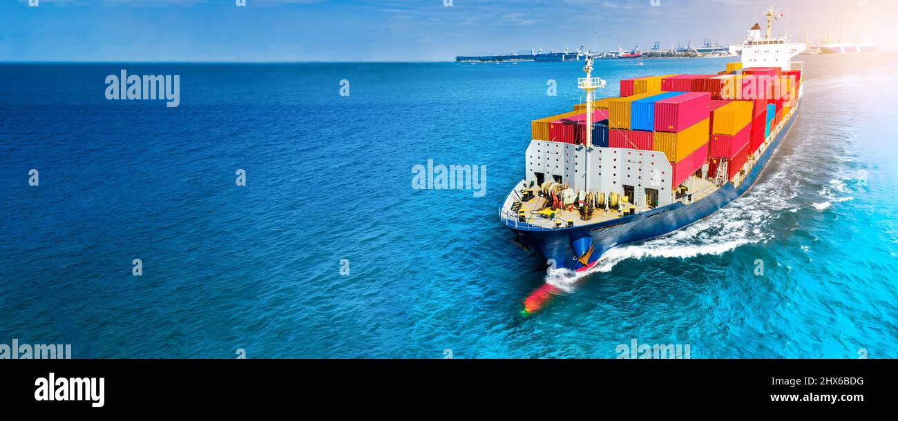 Vista laterale aerea della nave da carico che trasporta il container e che corre sul mare blu per esportare merci dal porto del cantiere merci alla tecnologia oceanica personalizzata Foto Stock