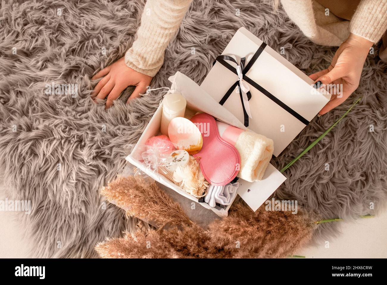 Scatola cura donna per le vacanze. Set regalo da donna in crema e rosa  morbido con asciugamano, calze, sale da bagno, candela e maschera per  dormire Foto stock - Alamy