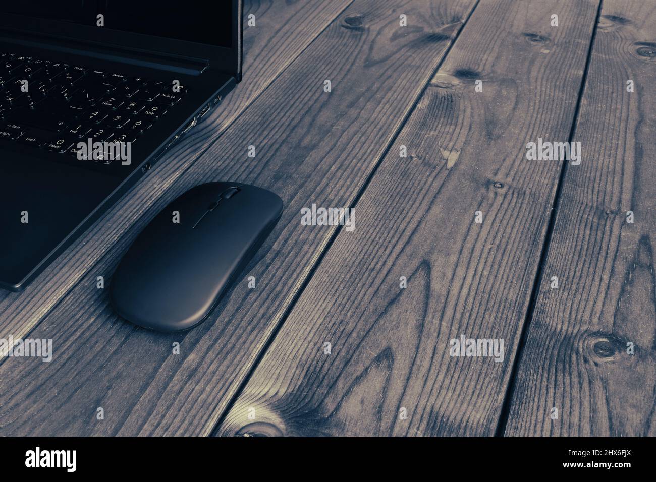 Computer portatile e computer mouse moderno in primo piano su una superficie di legno scuro. Foto Stock