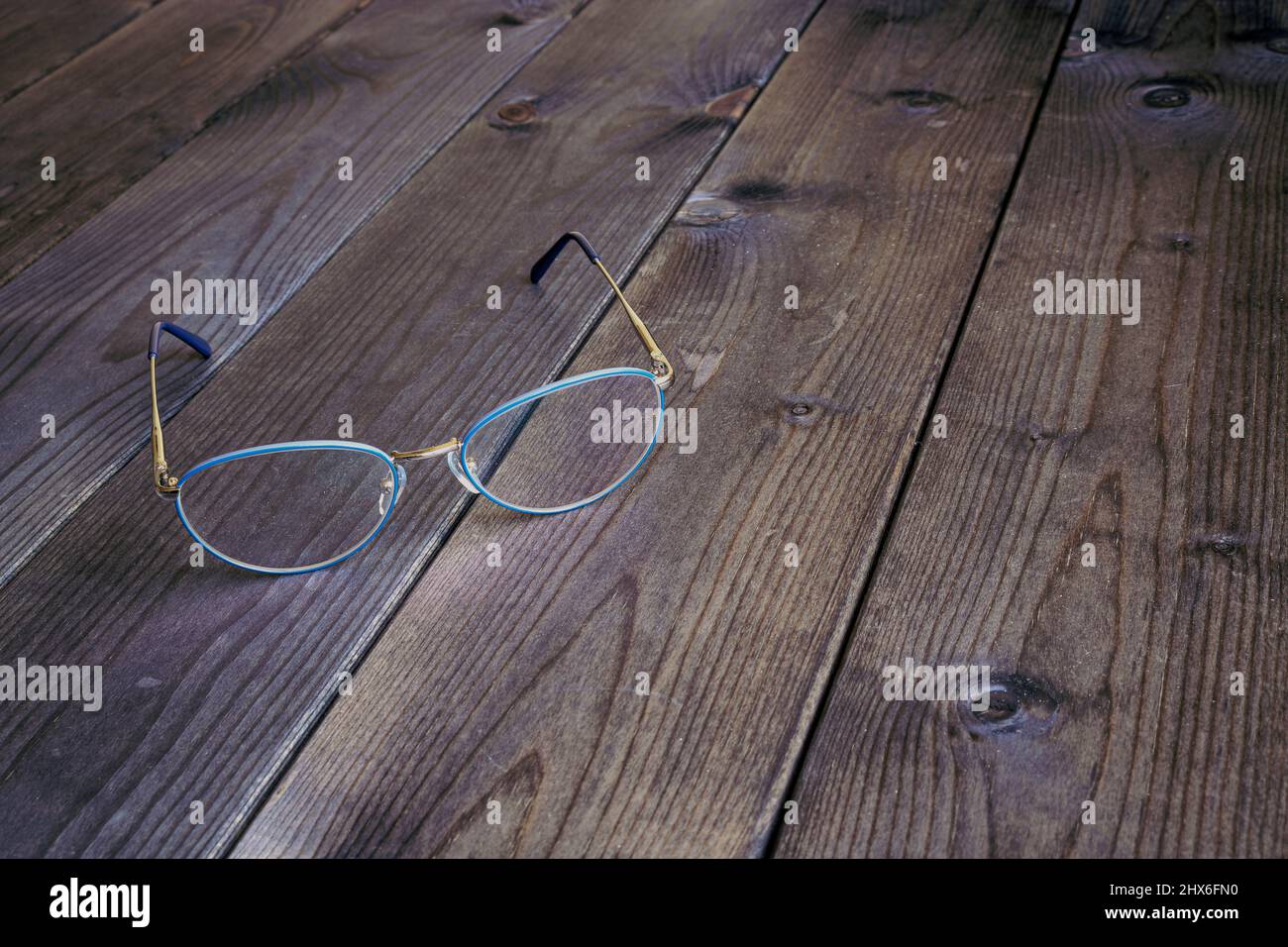 Occhiali moderni ed eleganti su un tavolo vintage di legno scuro. Foto Stock