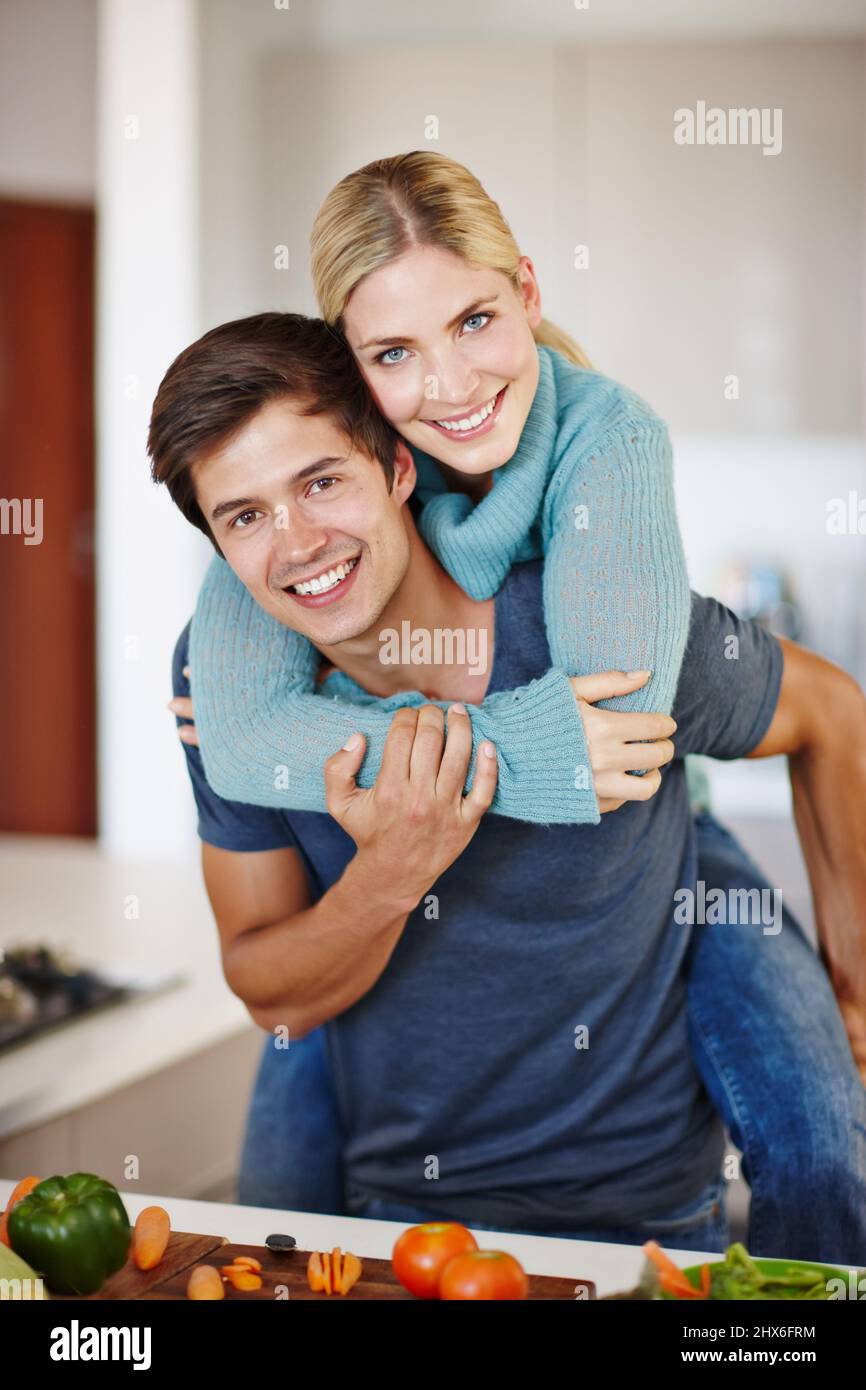 I pasti e le memorie sono fatti qui. Scatto di una giovane coppia felice che condivide un momento affettuoso insieme mentre prepara un pasto. Foto Stock