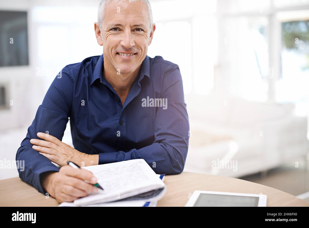 Senso delle finanze domestiche. Ritratto di un uomo maturo che usa un tablet digitale a casa. Foto Stock