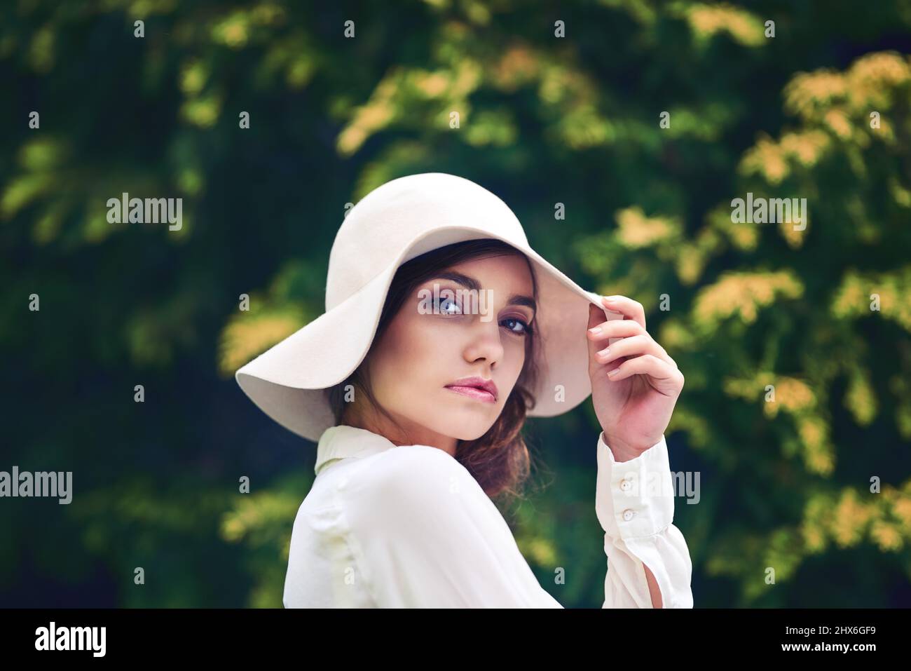 La sua bellezza è assolutamente unica nel suo genere. Ritratto di una giovane donna attraente che indossa un cappello elegante all'aperto. Foto Stock