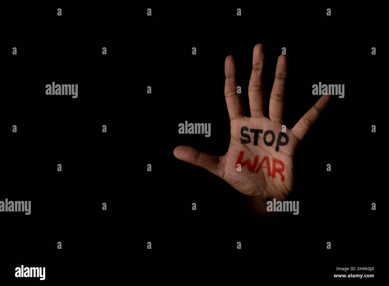 mano irriconoscibile con stop war scritto mostrando con spazio copia in sfondo scuro - concetto di indipendenza e libertà Foto Stock