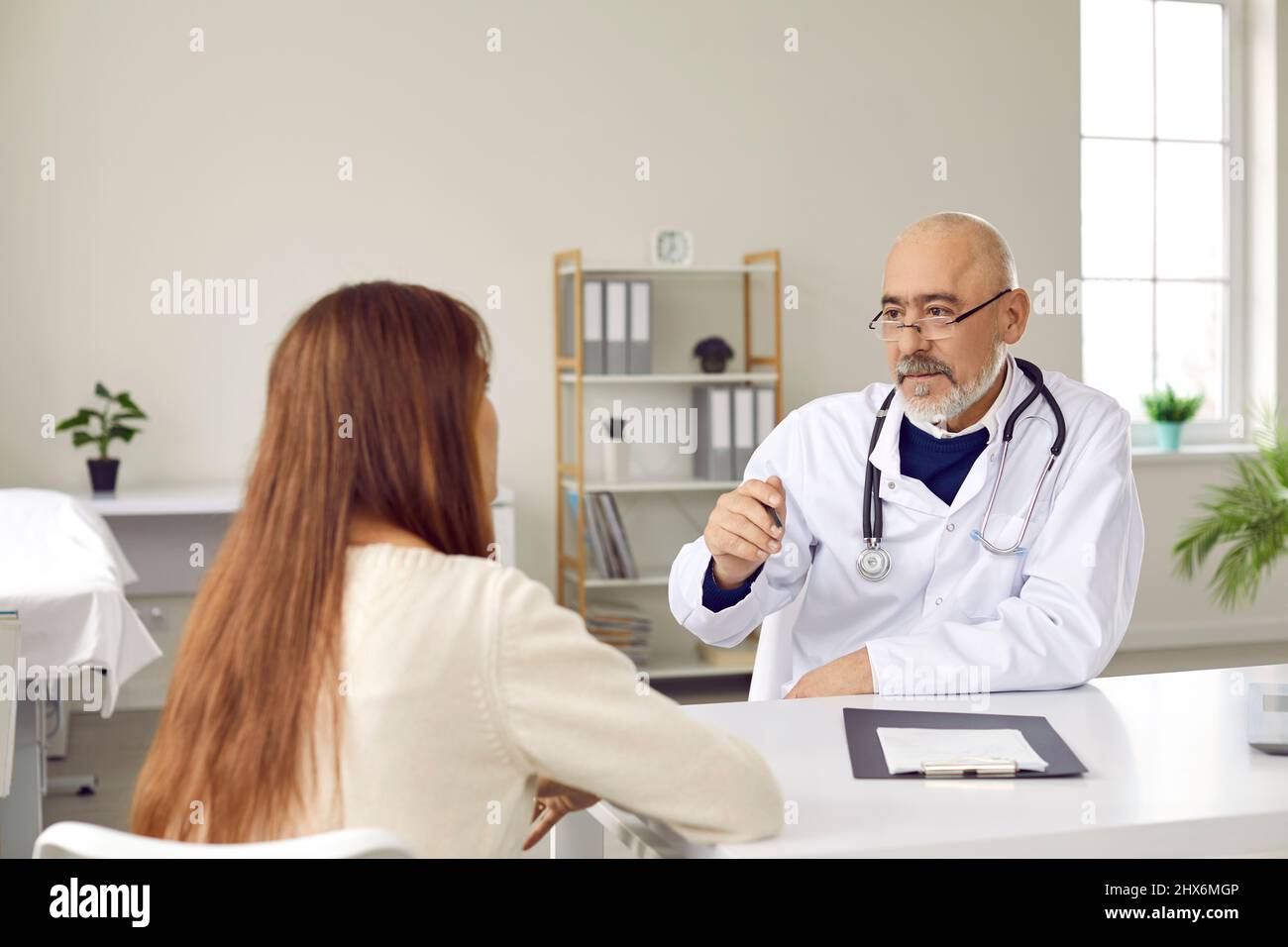 Il medico di sesso maschile consulta la paziente in ospedale Foto Stock
