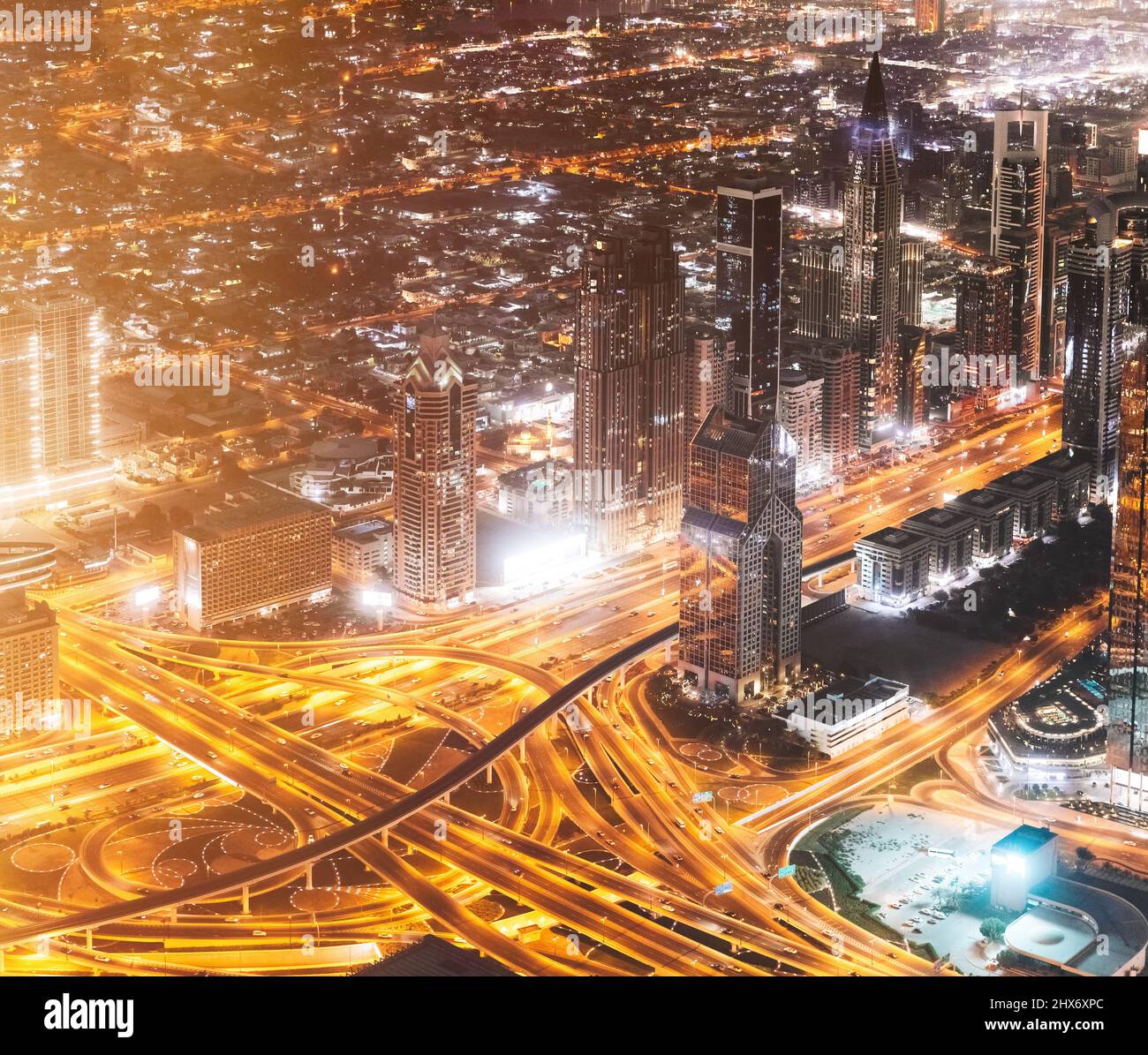 Vista aerea dello skyline urbano di notte. Città sfondo di un paesaggio urbano illuminato con grattacieli e moderna architettura urbana a Dubai Foto Stock