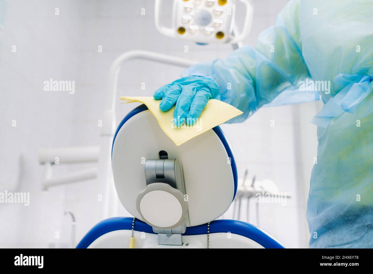 Un'infermiera disinfetta le superfici di lavoro nell'ufficio del dentista. Foto Stock