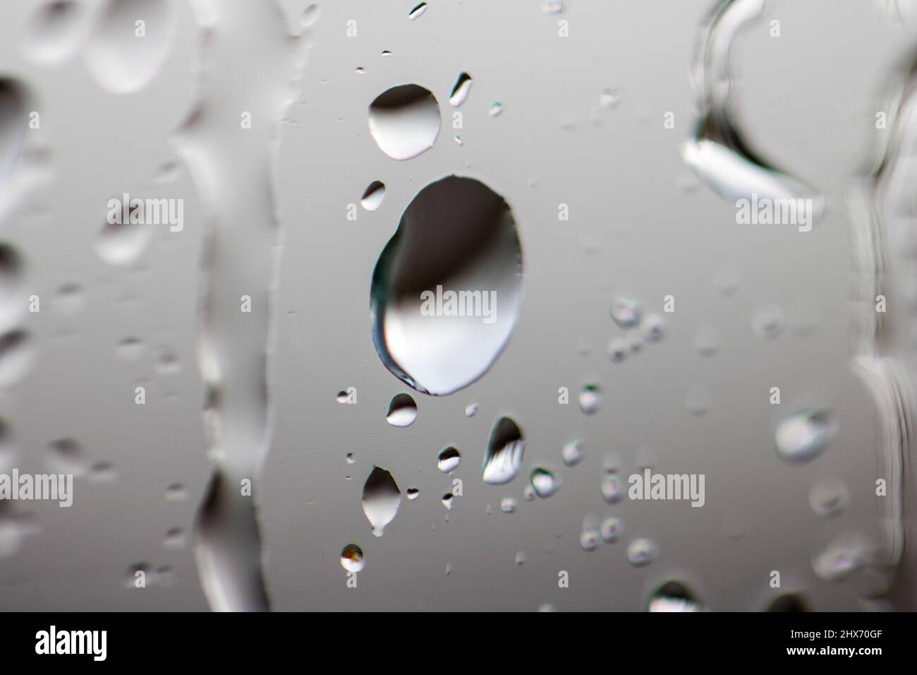 Foto macro di una goccia d'acqua su una finestra Foto Stock