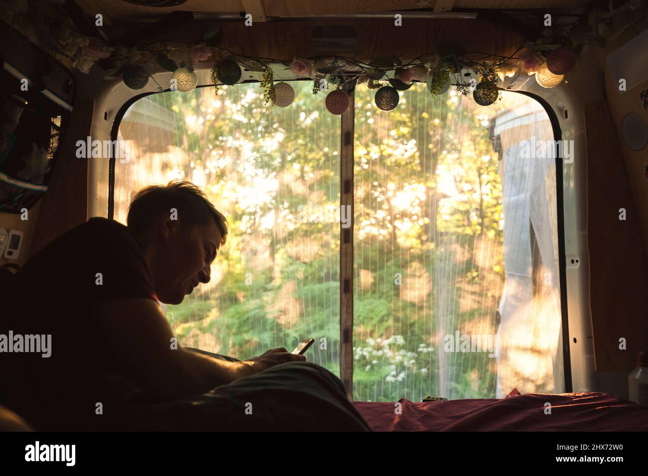 Giovane uomo che riposa in camper furgone Foto Stock