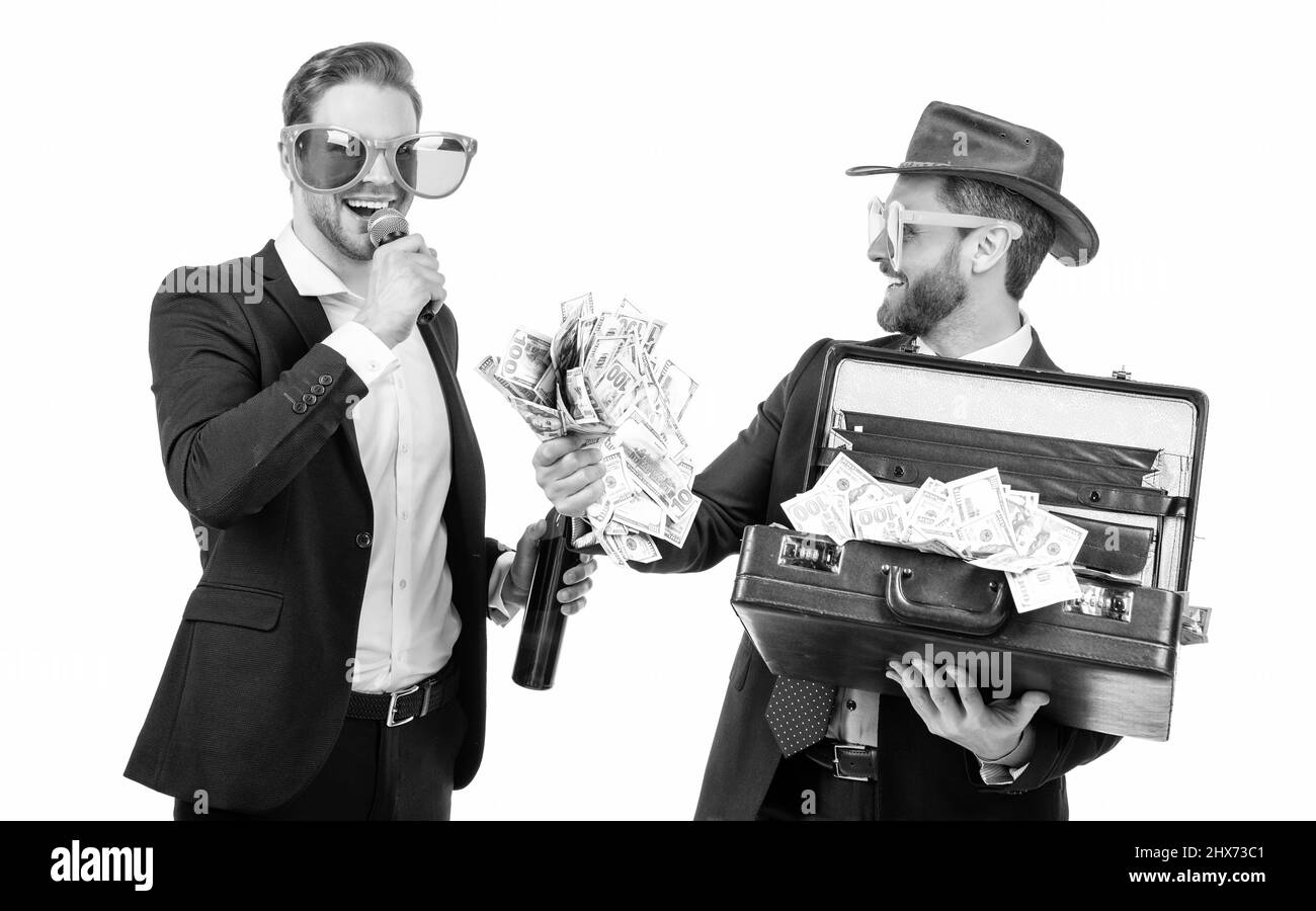 Showman annuncia felice vincitore jackpot tenendo in mano suitcase di denaro isolato su bianco, vincere Foto Stock
