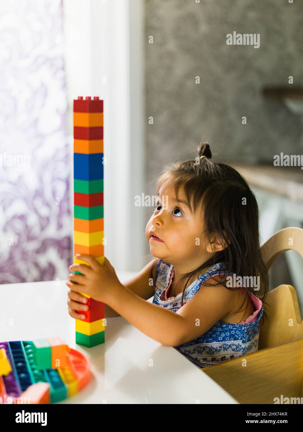 Ragazza impilando blocchi a tavola Foto Stock