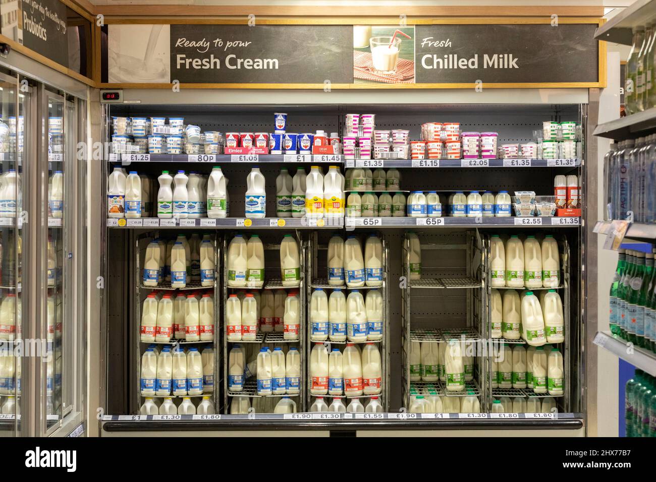 Prezzi dei prodotti lattiero-caseari visti sugli scaffali di un supermercato Tesco. Si dice che i prezzi dei prodotti alimentari, tra gli altri costi di vita, aumenteranno nei mesi a venire Foto Stock