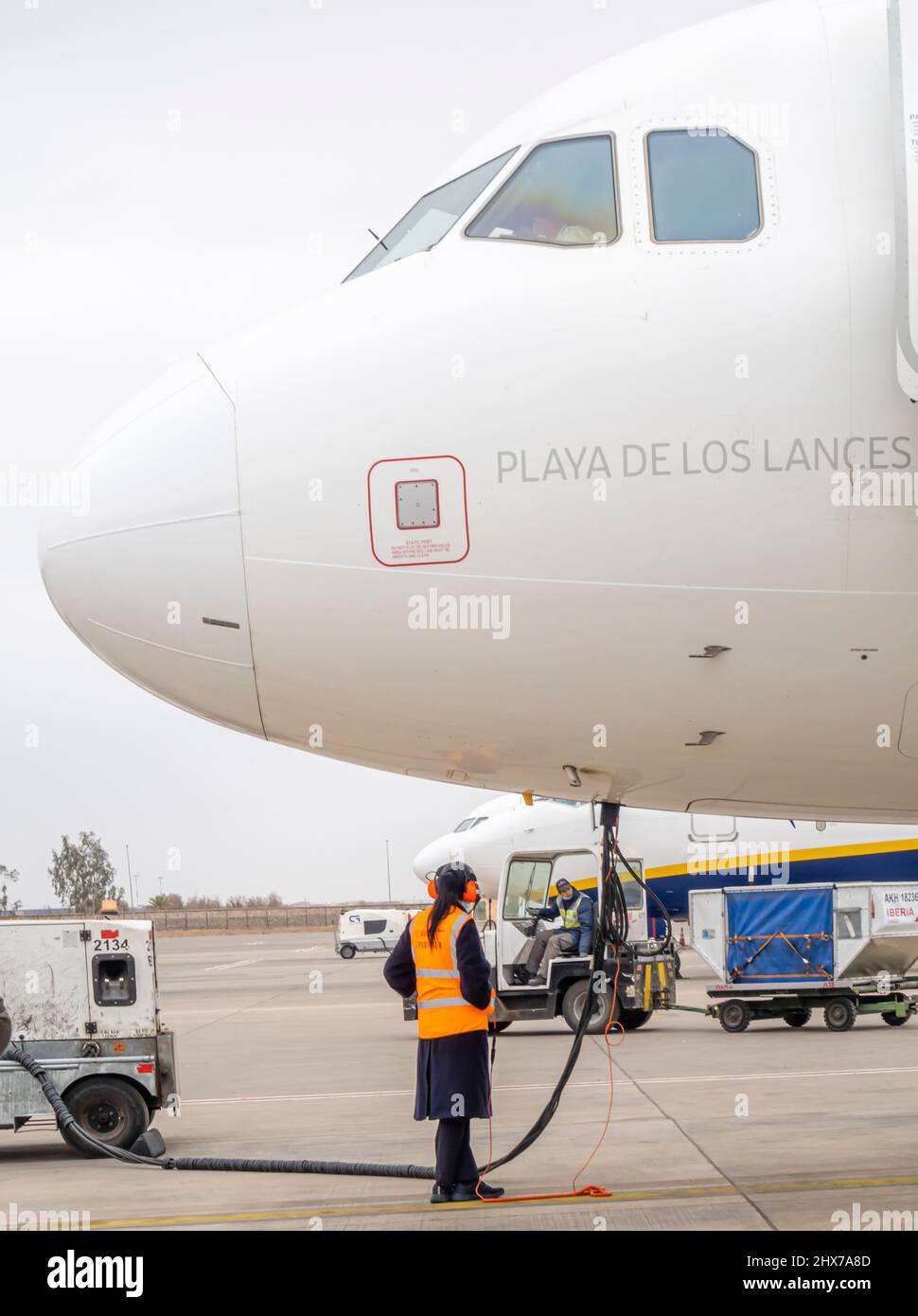 Un'impiegato di lavoro femminile che si rifornisce delle compagnie aeree Iberia Airbus A320 velivolo a doppio motore a reazione nell'aeroporto di Marrakech Menara, Marocco, Nord Africa Foto Stock