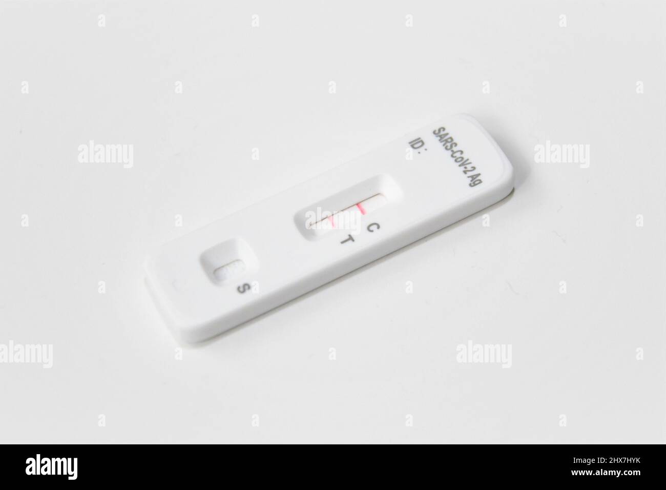 Un antigene COVID-19 positivo, flusso laterale, autotest. Test bianco isolato su sfondo bianco. La linea rossa indica un risultato positivo. Foto Stock