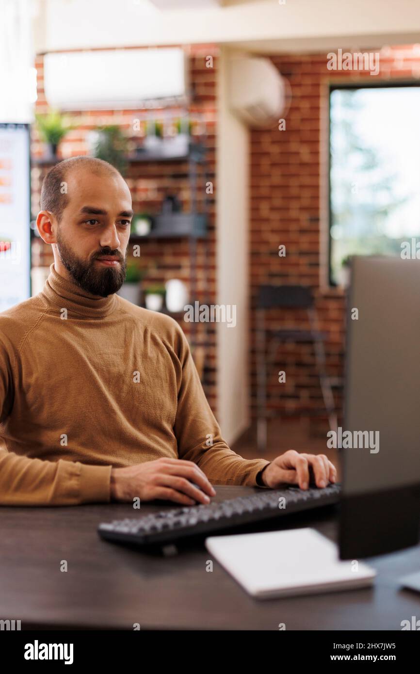 Imprenditore aziendale che ricerca idee di investimento e strategie finanziarie. Consulente dell'agenzia di marketing seduto alla scrivania mentre sviluppa la campagna di promozione del progetto di avvio. Foto Stock
