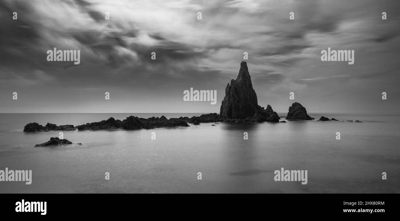 Una vista orizzontale in bianco e nero delle scogliere e della barriera corallina di Las Sirenas in Andalusia Foto Stock