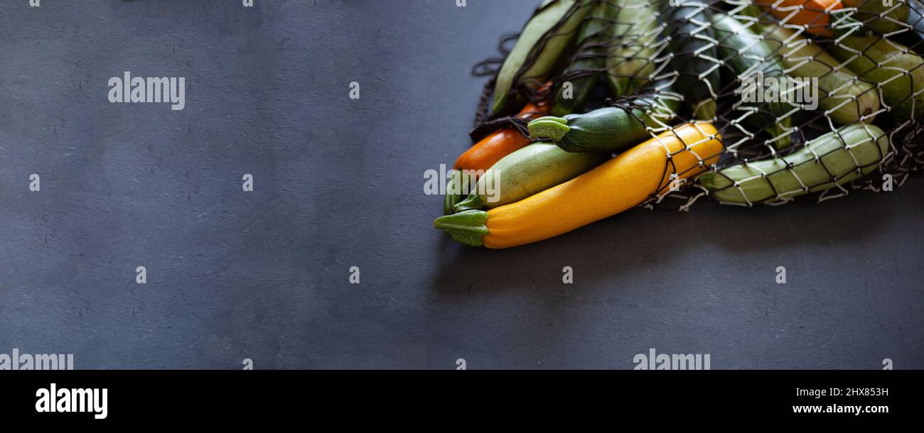 Zucchine multicolore gialle, verdi, bianche, arancioni sul tavolo da primo piano. Sfondo alimentare. Zucchine fresche raccolte, zucca estiva tagliata. Zucchine verdi selezionate. Coniglietto con spazio per la copia Foto Stock