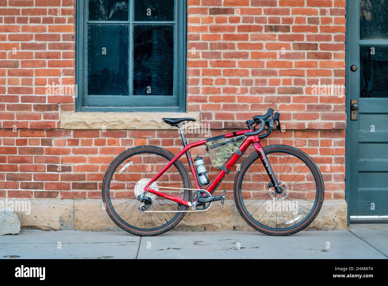 bici in ghiaia con telaio in carbonio leggero e trasmissione wireless contro il vecchio muro di mattoni Foto Stock