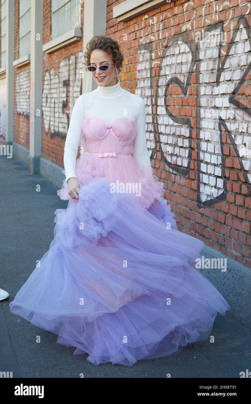 MILANO, ITALIA - 23 FEBBRAIO 2022: Donna con tulle rosa e viola e dolcevita bianco prima della sfilata di moda Fendi, Milano Fashion Week Street sty Foto Stock